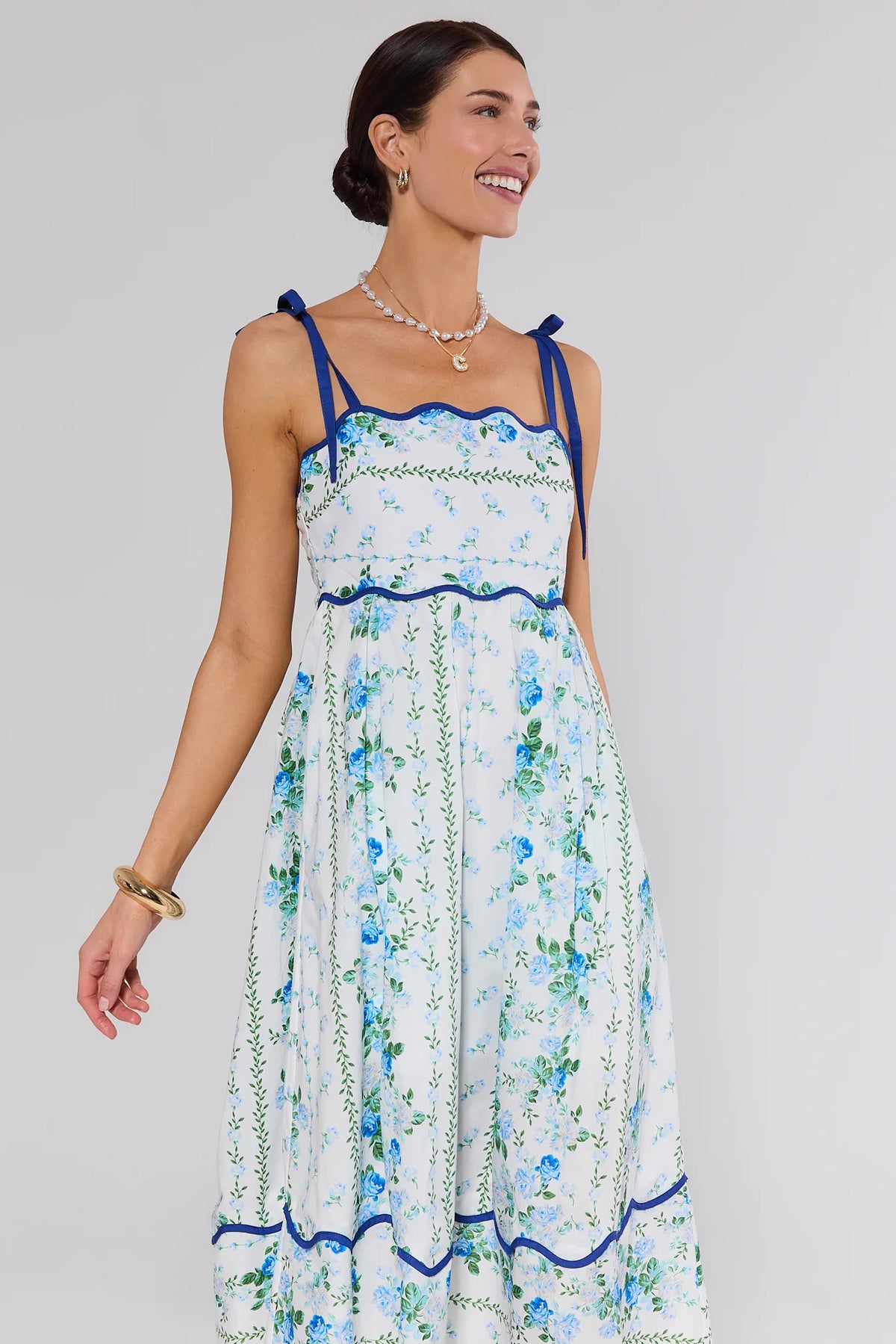 Flora Blue Floral Print Midi Dress with navy scalloped trim and tie straps, front angle on model | Avara