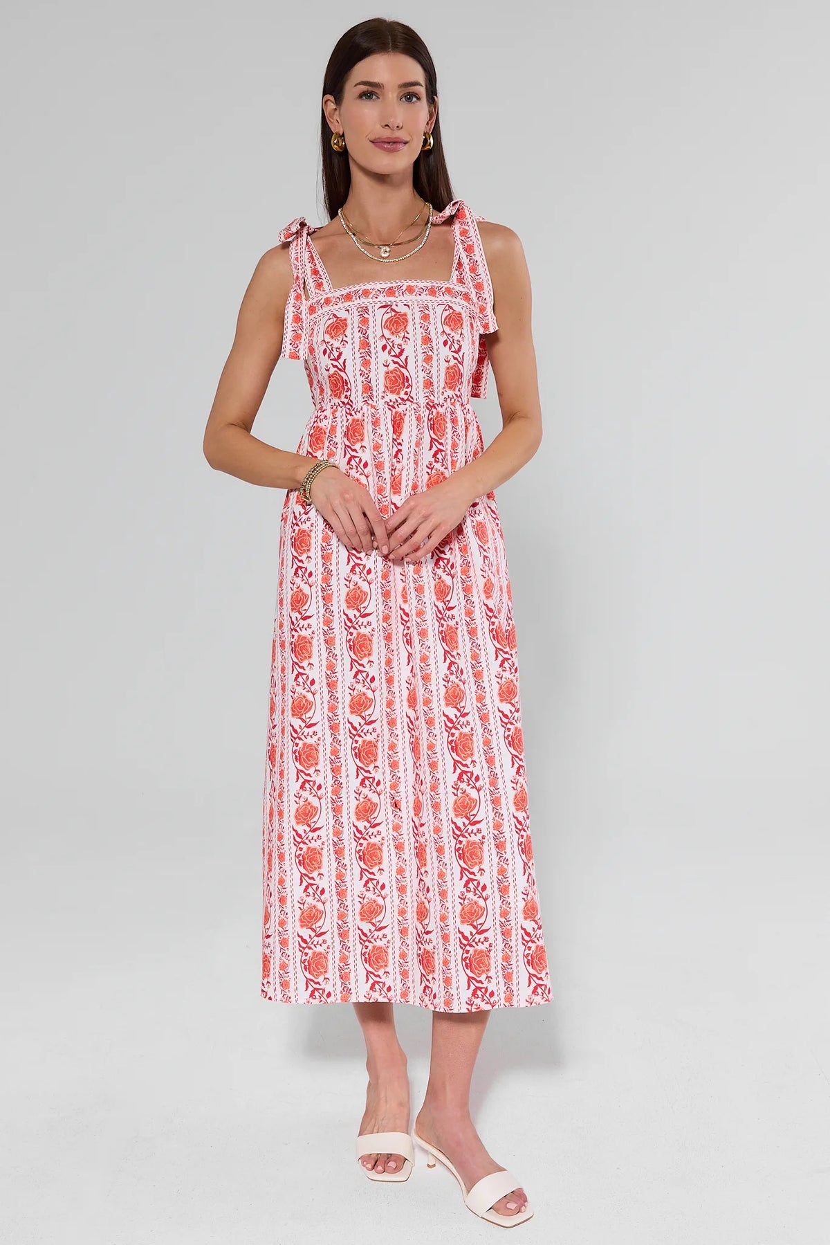 Woman wearing a red and white patterned dress on a gray background