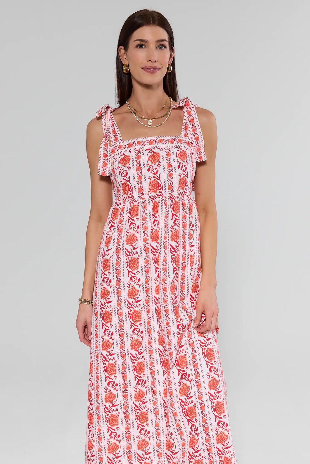 Woman wearing a red and white floral dress on a gray background