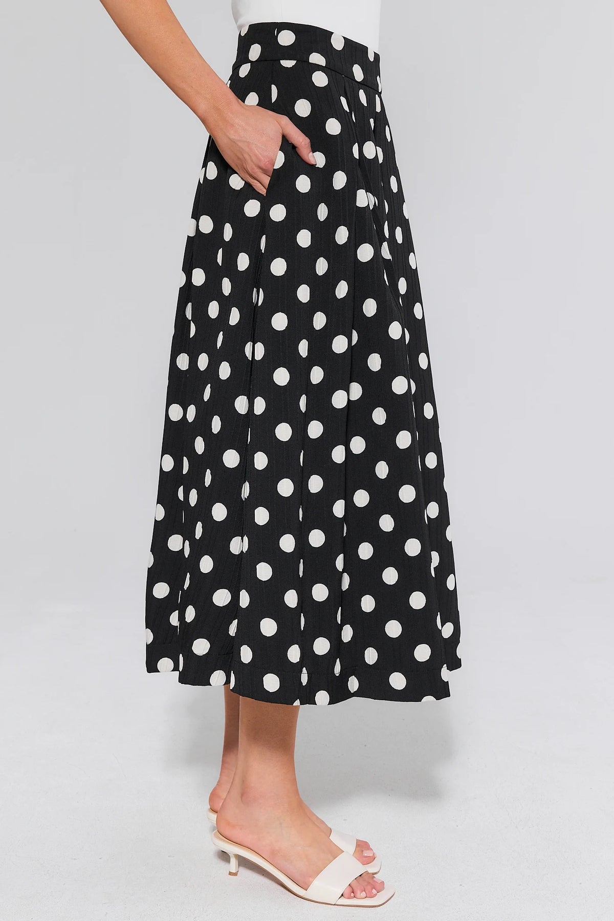 Collins Black Polka Dot Pleated Midi Skirt - Side View with Pocket Detail | Avara