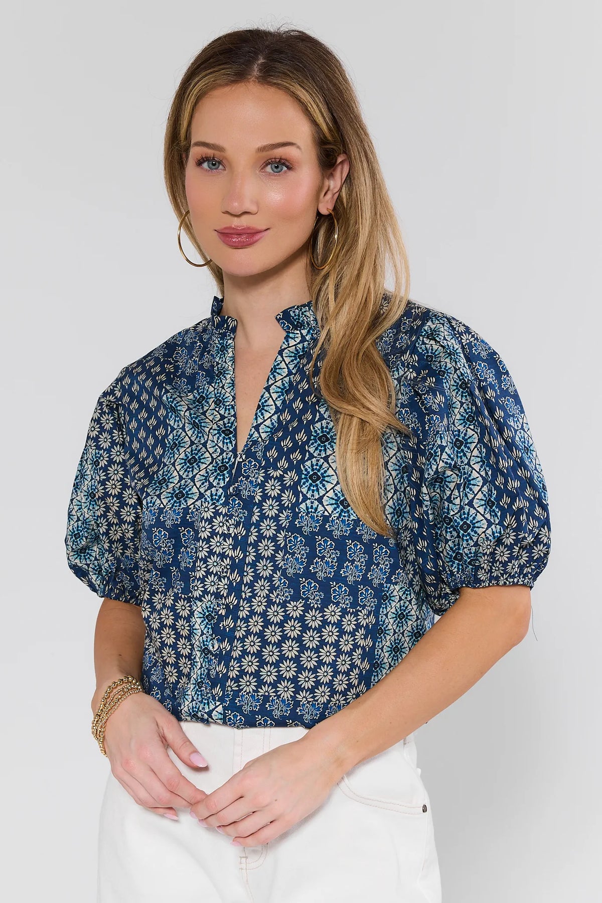 Woman wearing a blue floral blouse against a white background