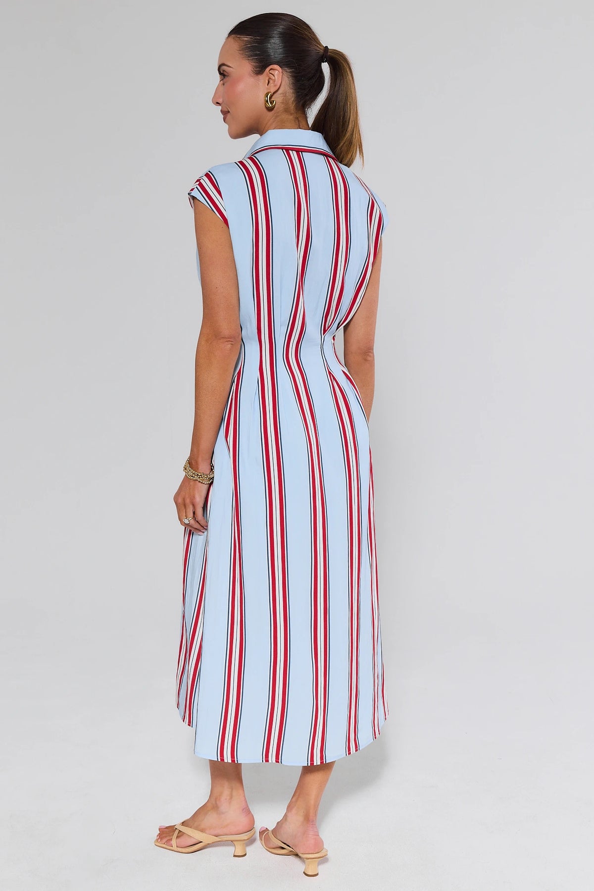 Woman wearing a red and white striped dress on a plain background
