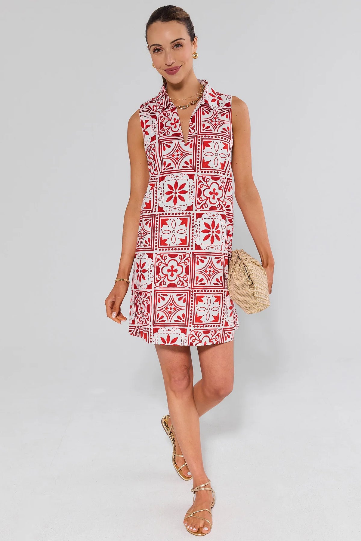 Woman wearing a ellen red and white patterned dress on a plain background