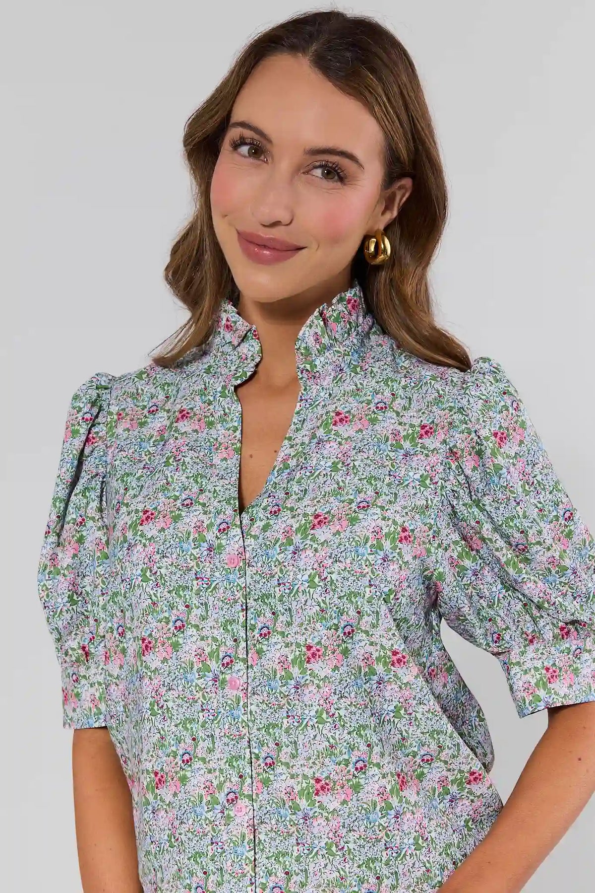 close up Woman wearing a floral blouse against a plain background