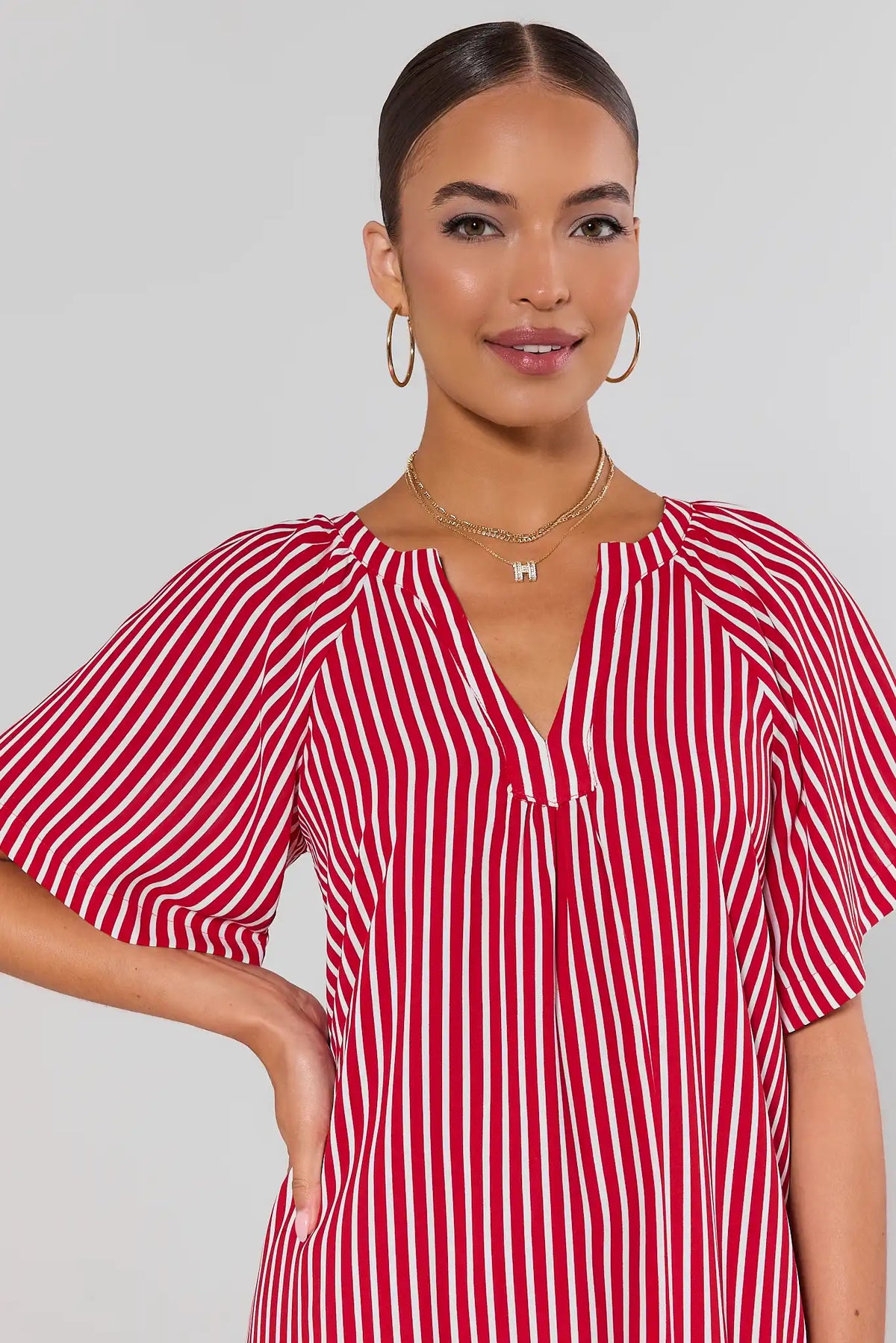 close up Woman wearing a red and white striped dress against a plain background