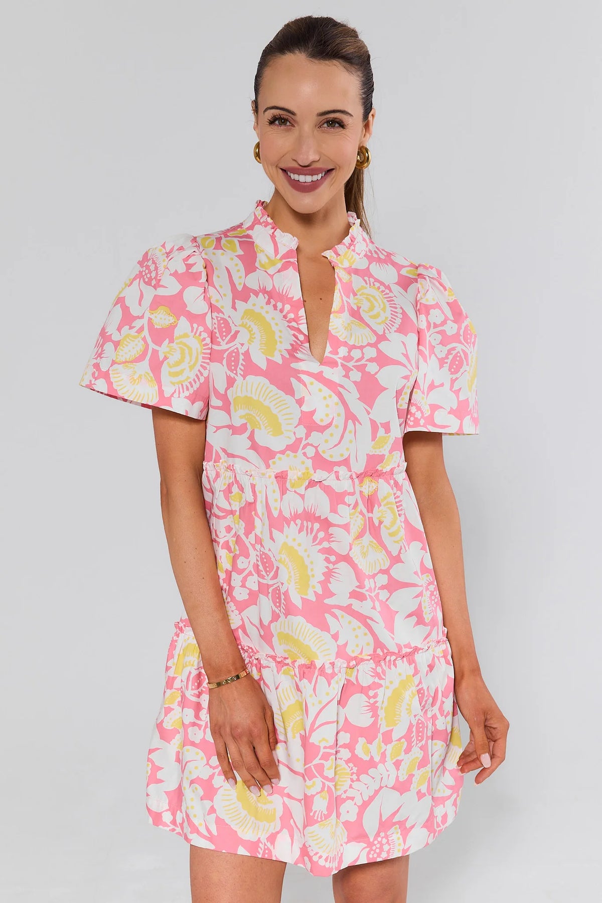 Evan Pink Floral Short Dress tiered silhouette front view with gold sandals and woven tote - On Model | Avara