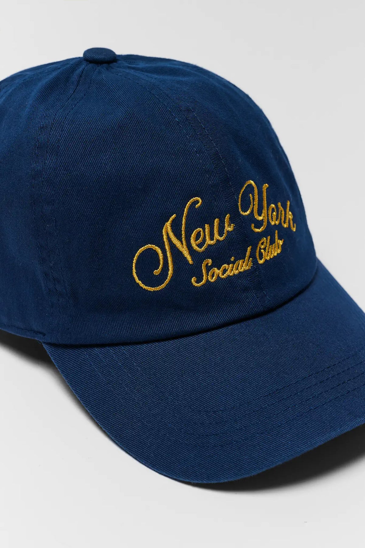 Blue cap with 'New York Social Club' embroidery on a light gray background