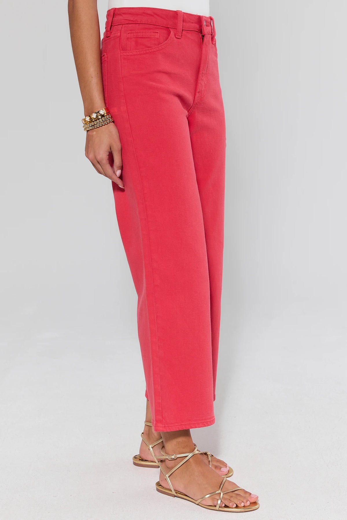 side shot Person wearing bright pink pants on a plain background