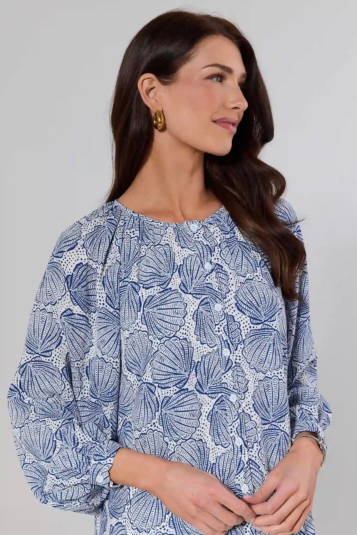 Close-up of blue seashell print top with relaxed silhouette and round neckline, on model | Avara