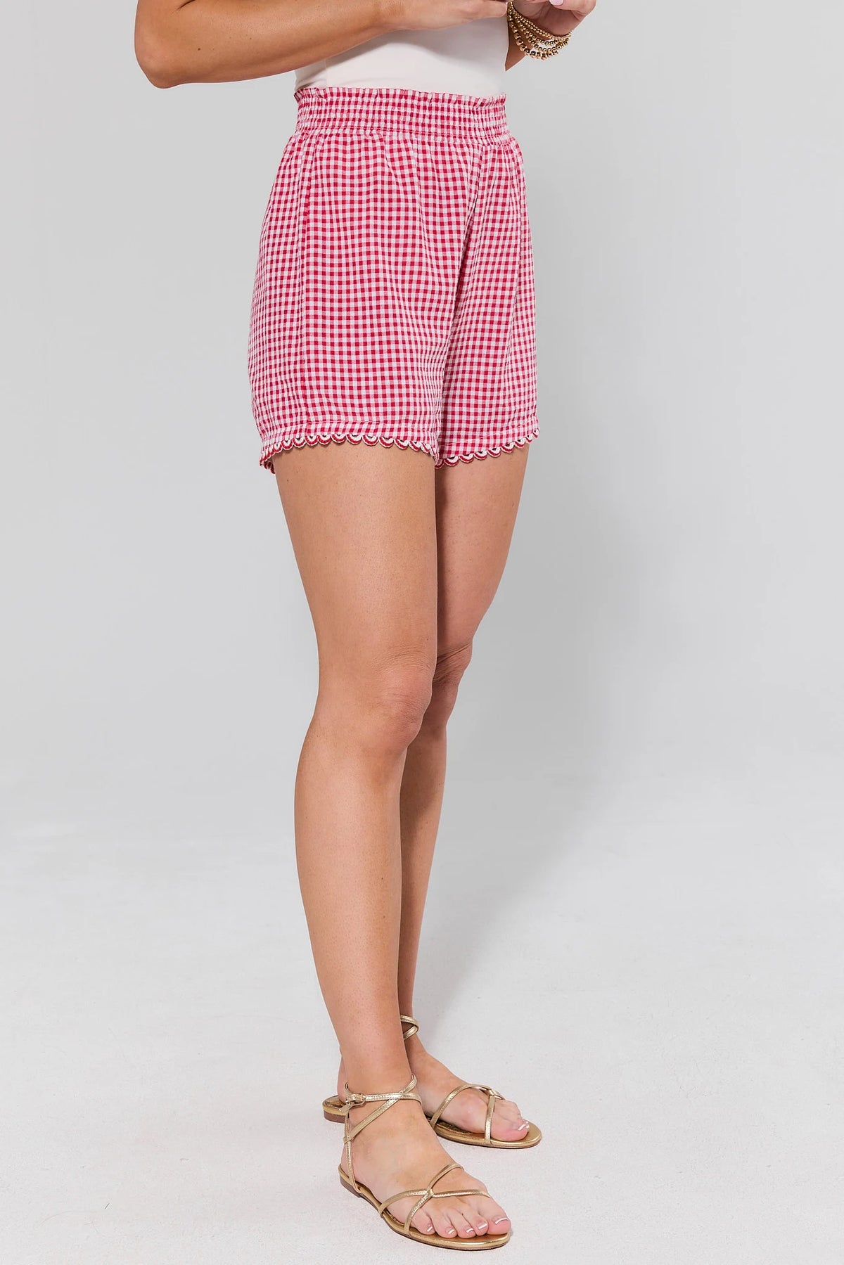 Red Gingham Mini Shorts with scalloped ric-rac hem and smocked waist - Side View On Model | Avara