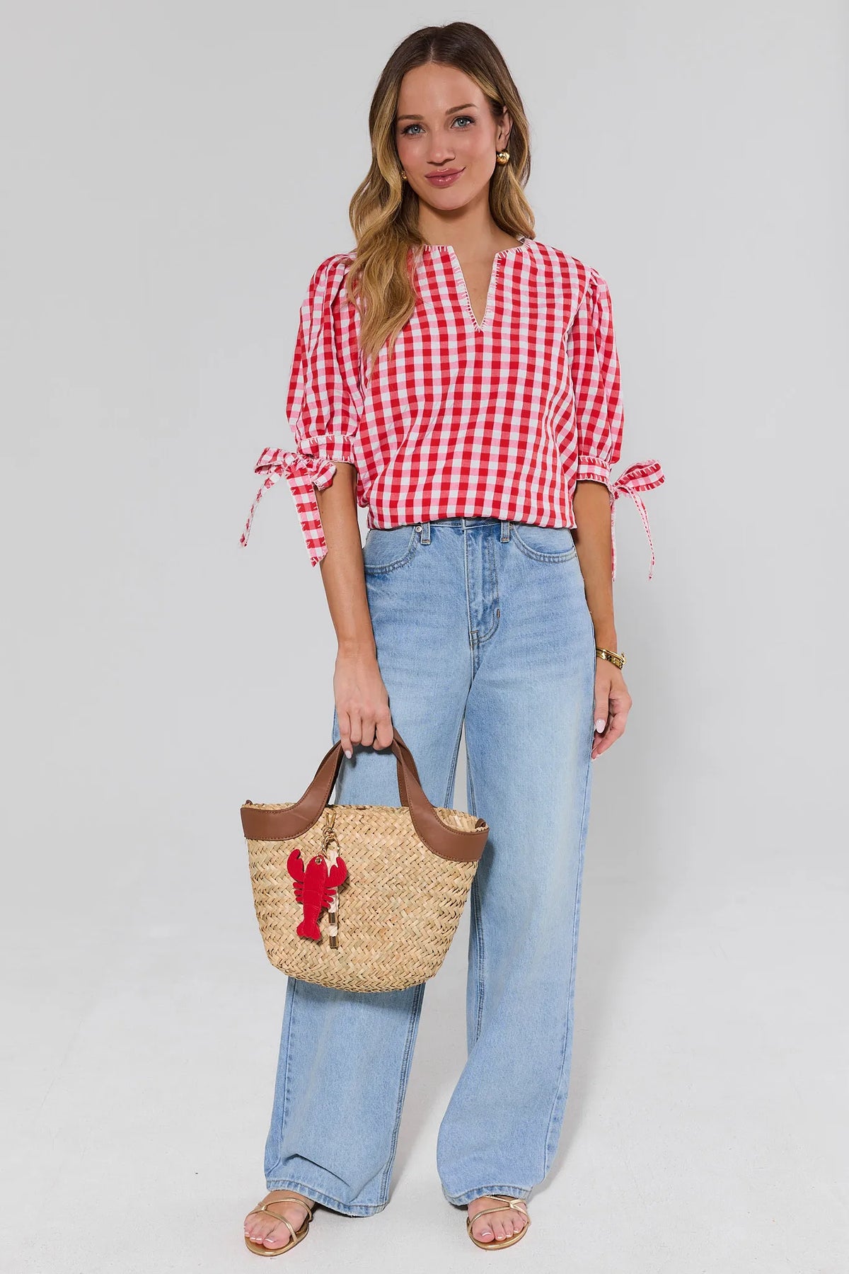Red gingham top styled with wide-leg jeans and straw lobster tote bag - Full Length View | Avara