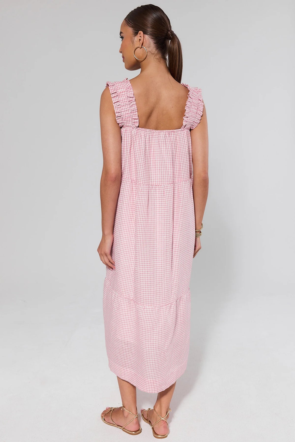Back view of red gingham midi dress showing ruffle shoulder straps, tiered skirt, and open square neckline | Avara