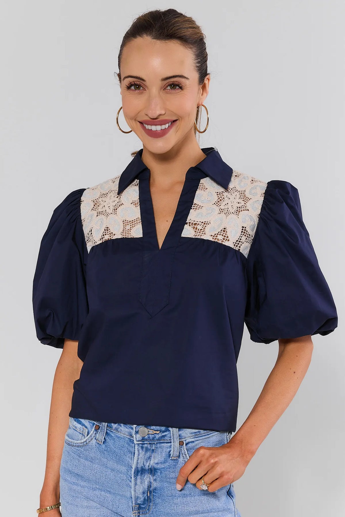 Navy crochet lace top with puff sleeves and cream lace yoke, front view on model with light-wash jeans | Avara