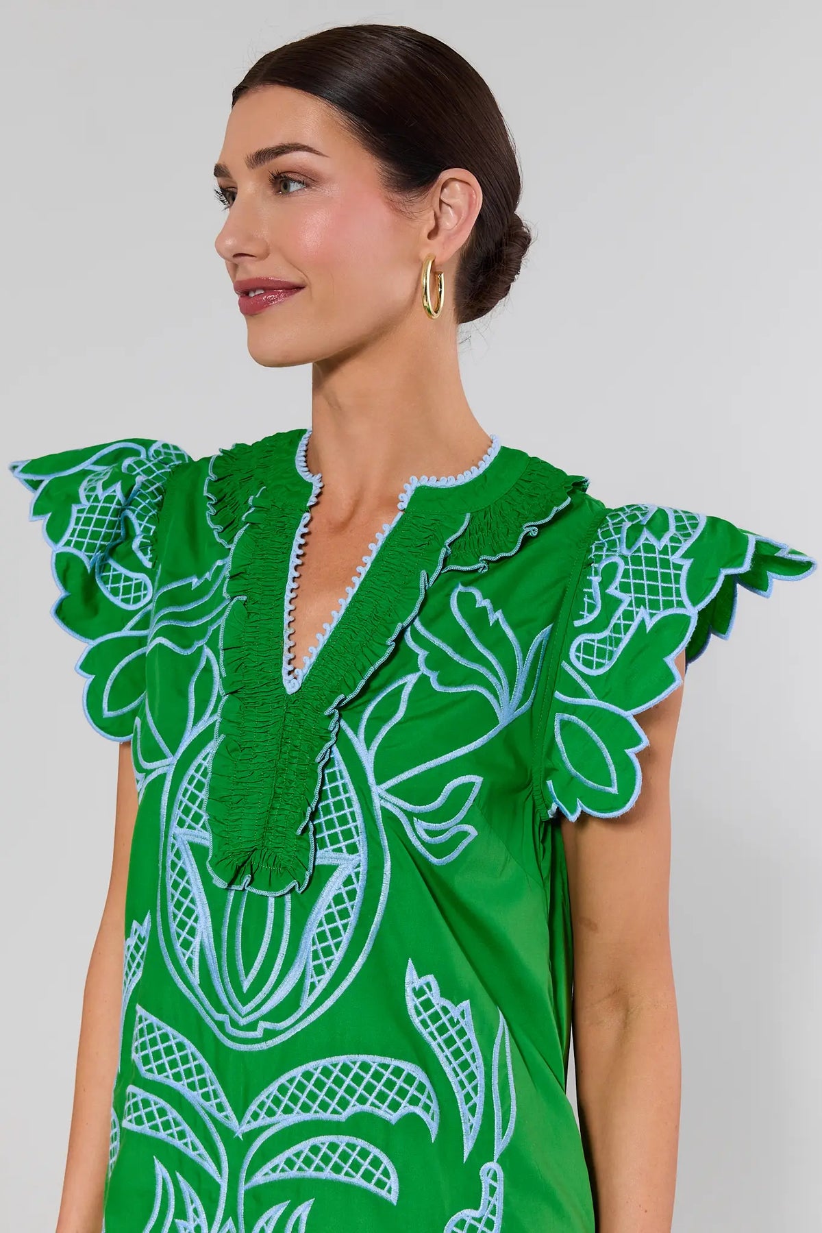 close up Woman wearing a green dress with white patterns on a gray background