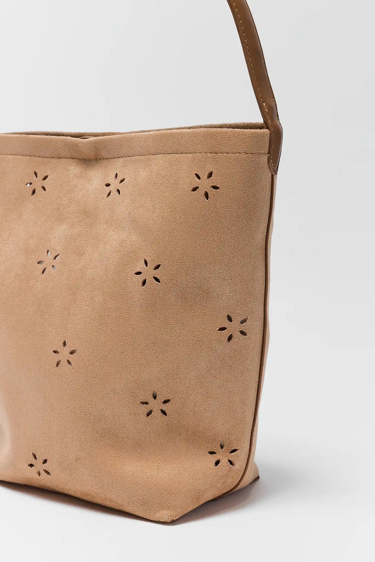 Tan handbag with star-shaped cutouts on a white background