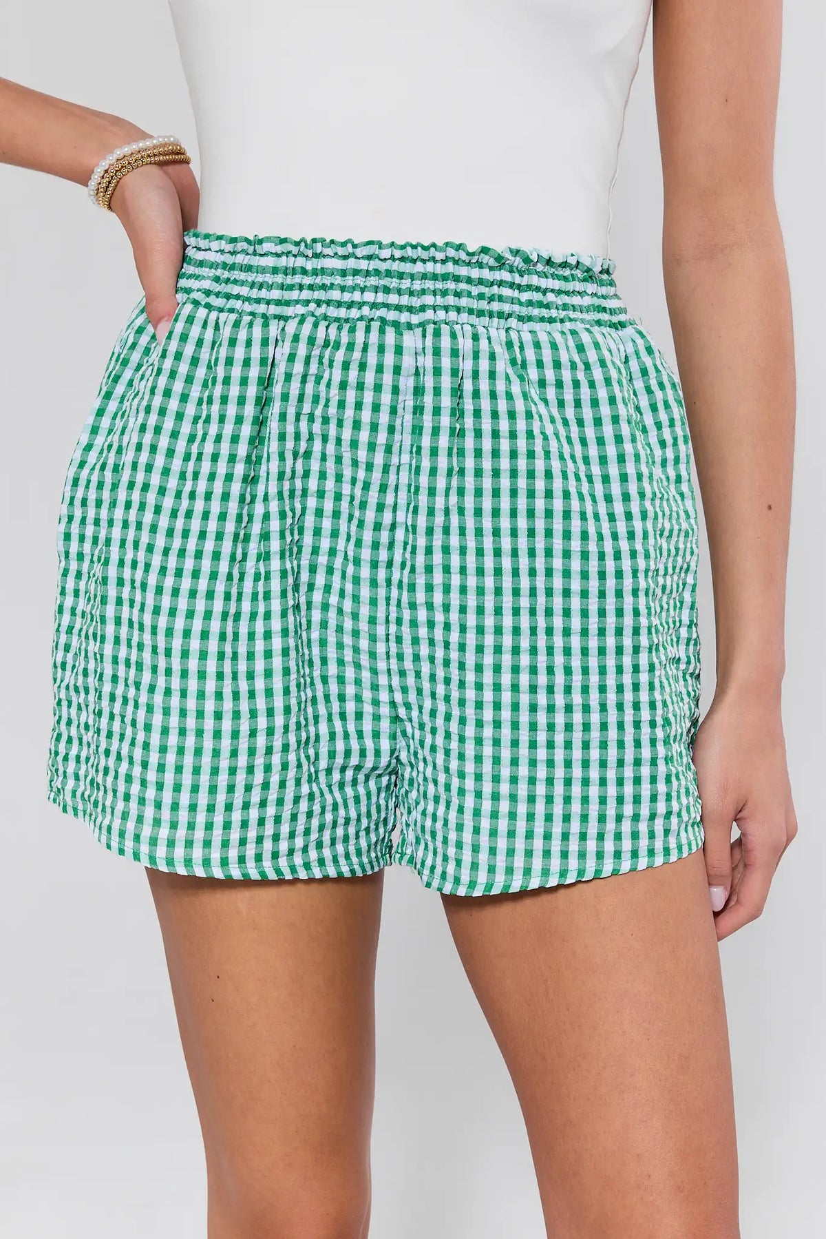 Green gingham elastic waist shorts close-up, smocked waistband detail on model, women's gingham shorts | Avara