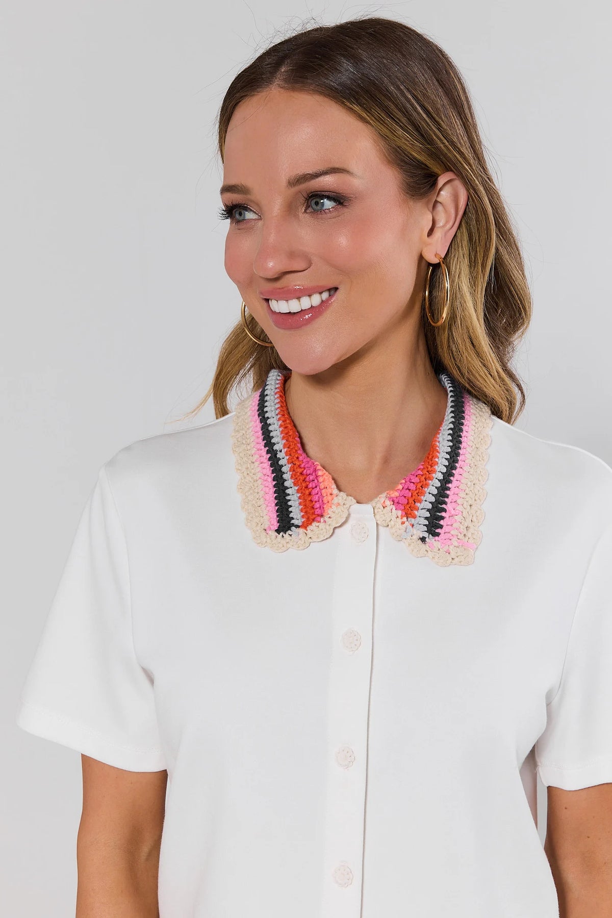 Close-up of white crochet collared top with pink orange black striped scallop collar detail | Avara