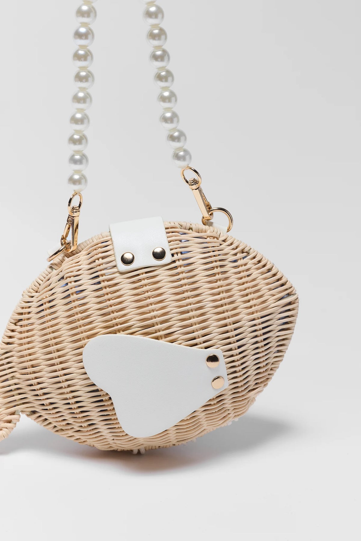Close-up of woven fish bag showing white snap closure detail and pearl beaded handle - Hardware Detail | Avara