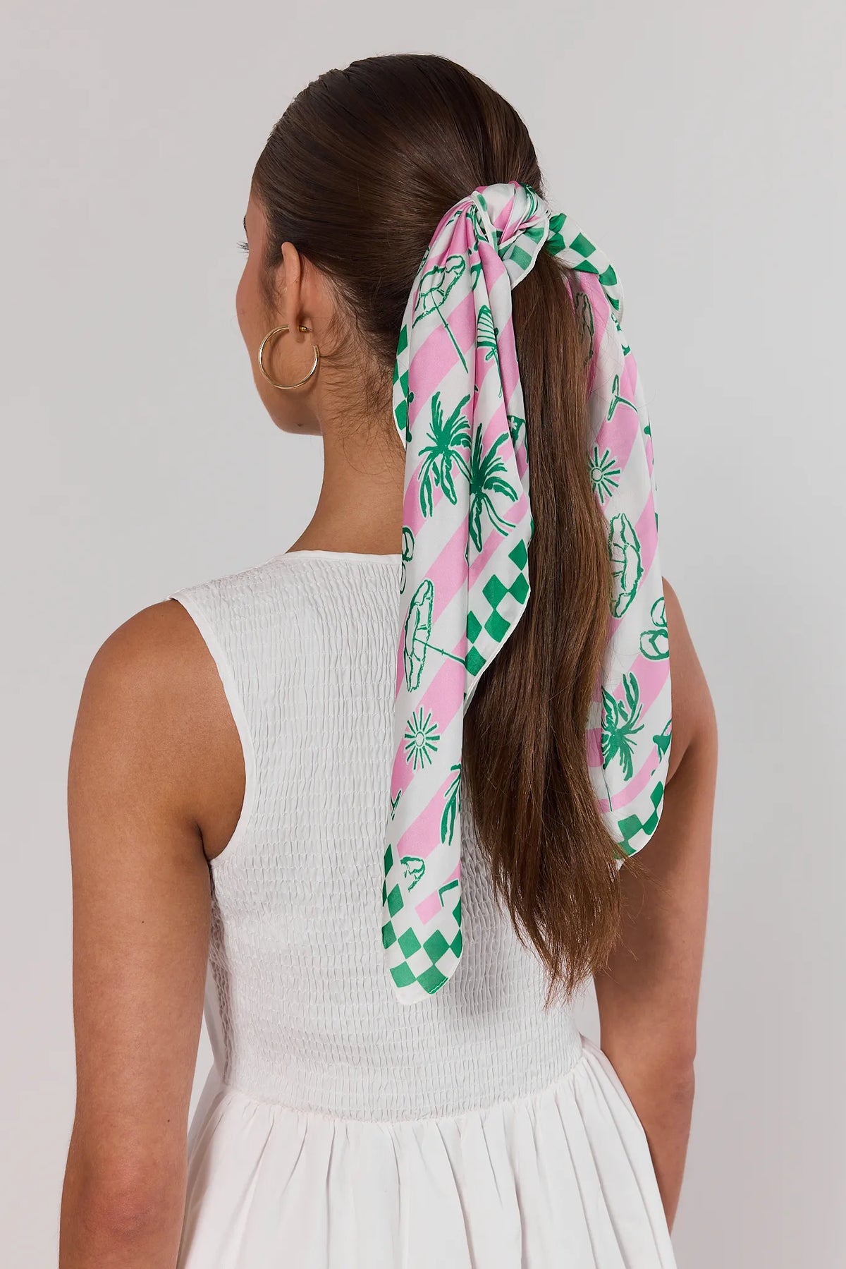 Woman wearing pink stripe patterned scarf tied in ponytail, green tropical print, back view | Avara