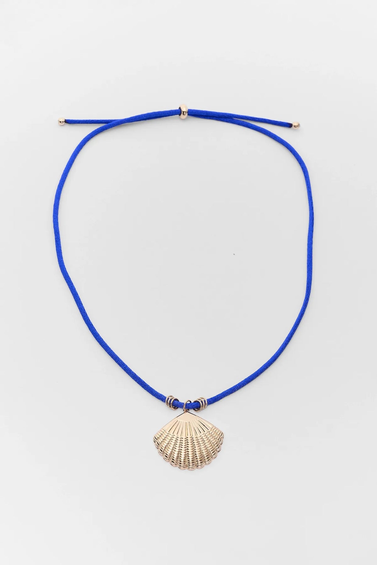 Blue cord shell charm necklace with gold-tone pendant, adjustable fit - Flat Lay | Avara