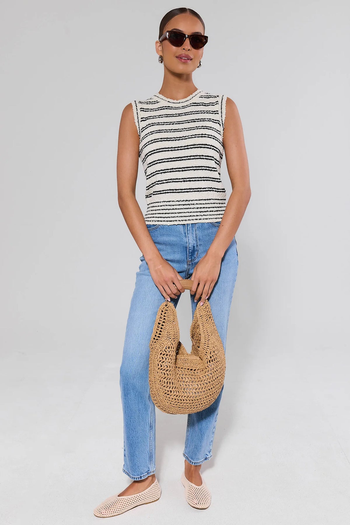 Woman in white striped knit tank top styled with jeans, woven bag and flats - Full Styled Look | Avara