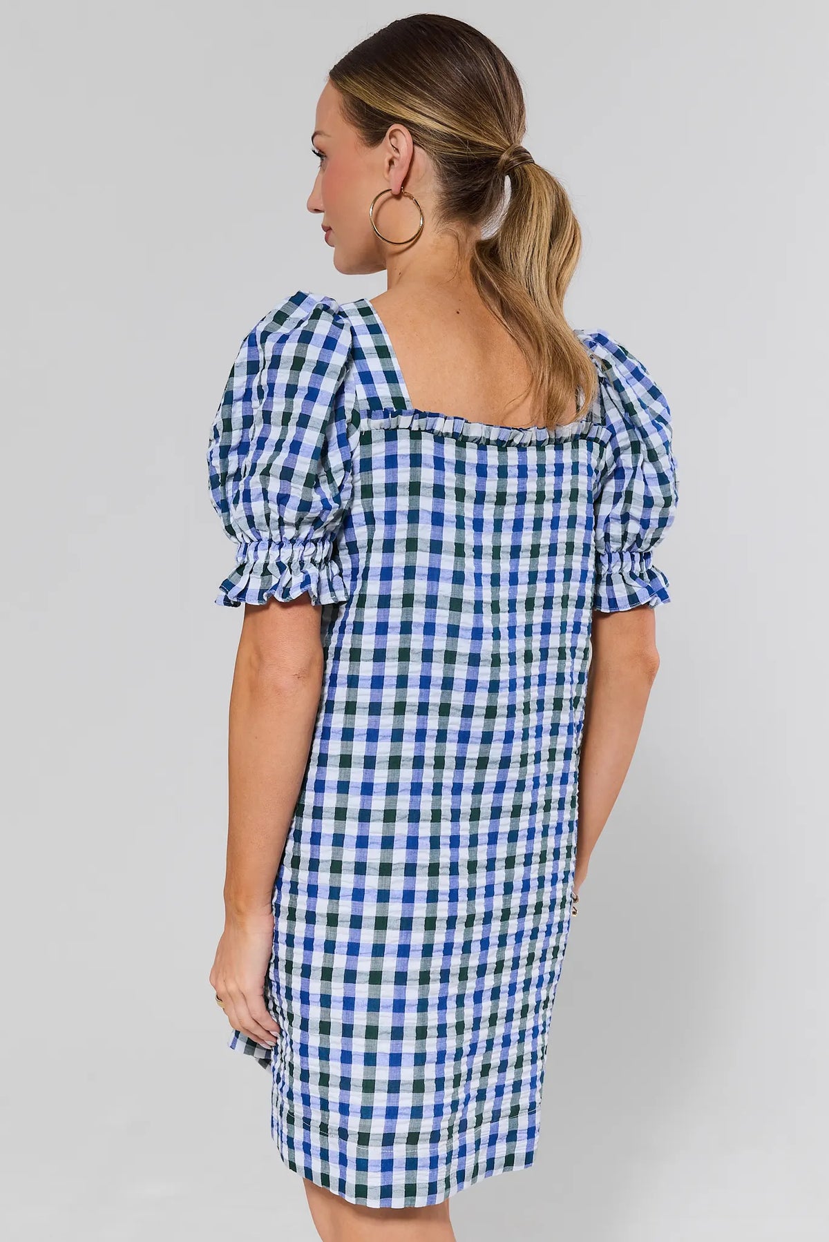 Back view of navy gingham short dress with square back neckline and puff sleeves on model | Avara