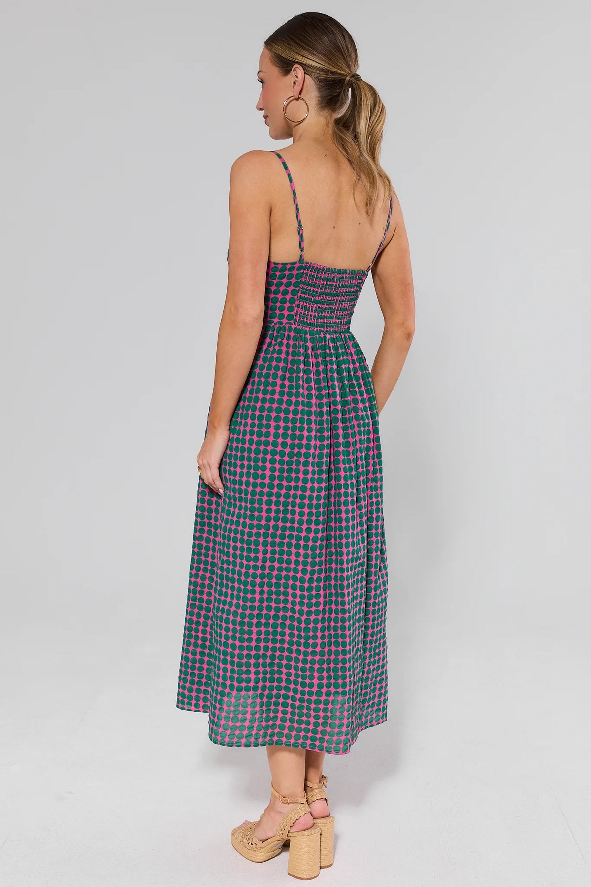 Pink polka dot maxi dress smocked back and spaghetti straps on model - Back View | Avara