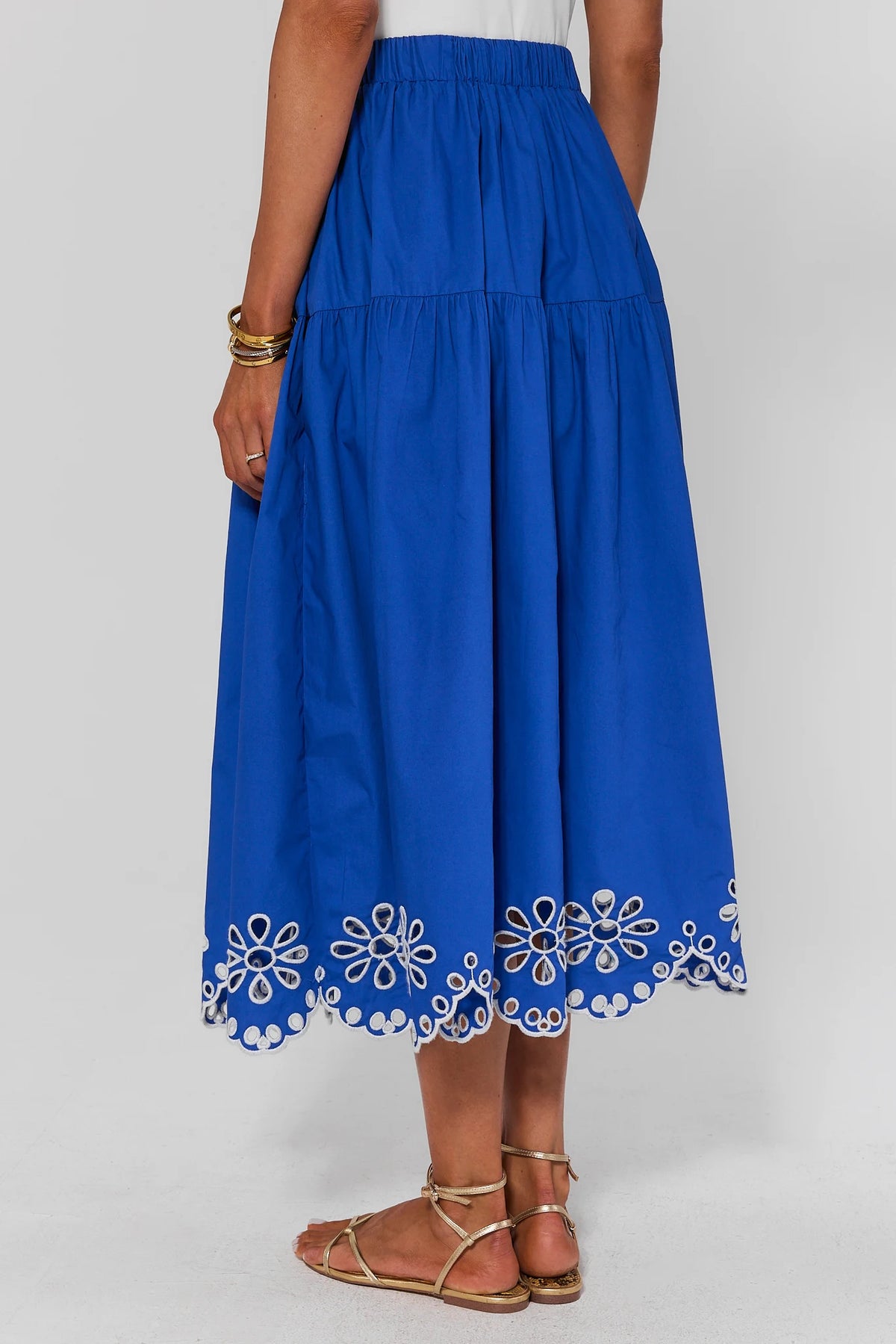 Blue skirt standing with floral embroidery on a white background
