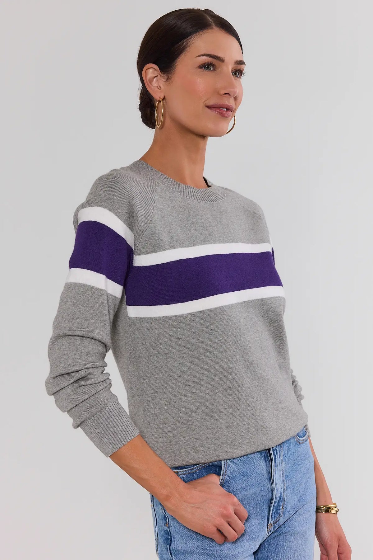 Dylan Purple Stripe Sweater side view showing purple and white stripe detail across chest and sleeve on model with jeans | Avara