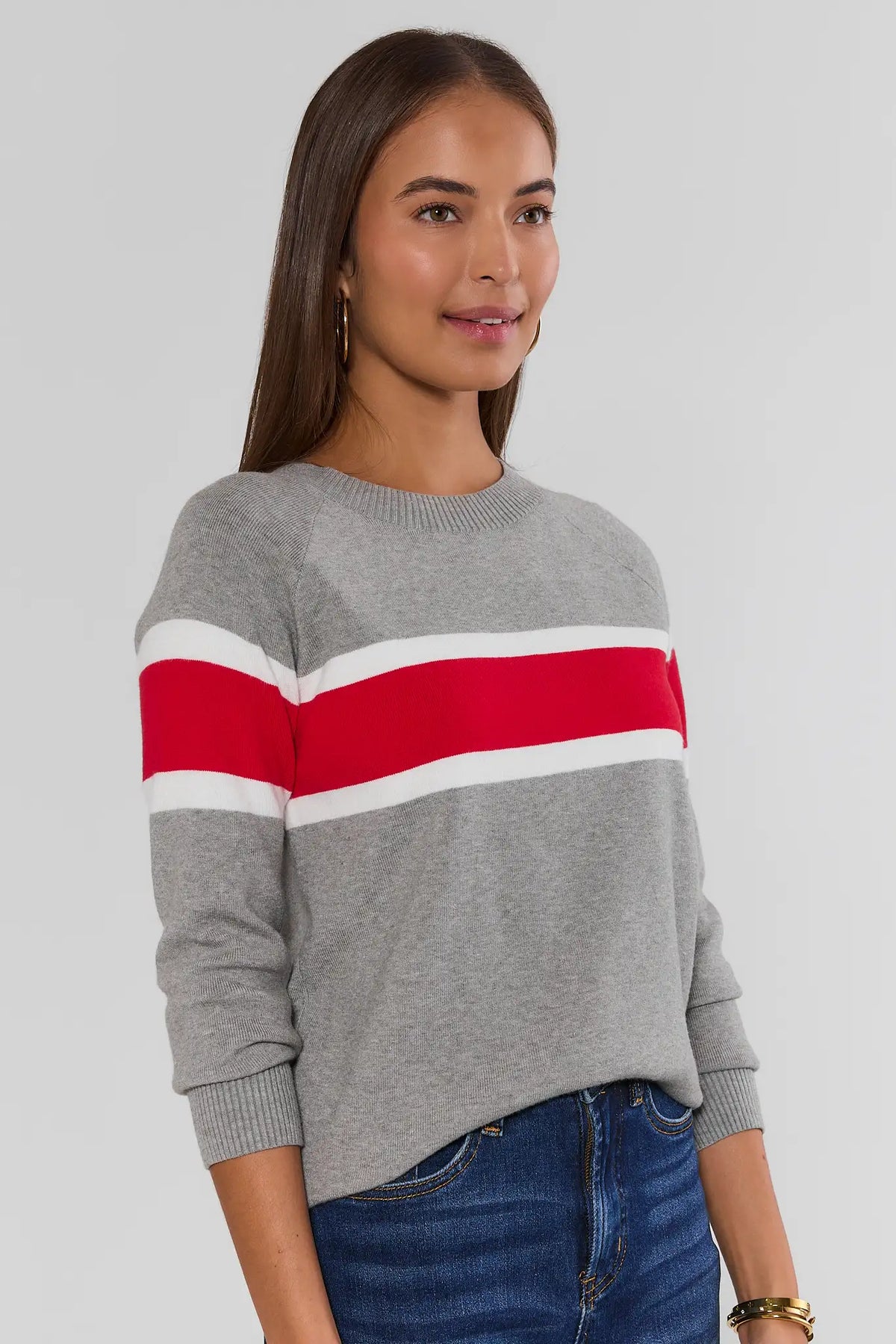 Dylan Red Stripe Sweater three-quarter side view, heather gray knit with red and white horizontal stripe, paired with blue jeans | Avara