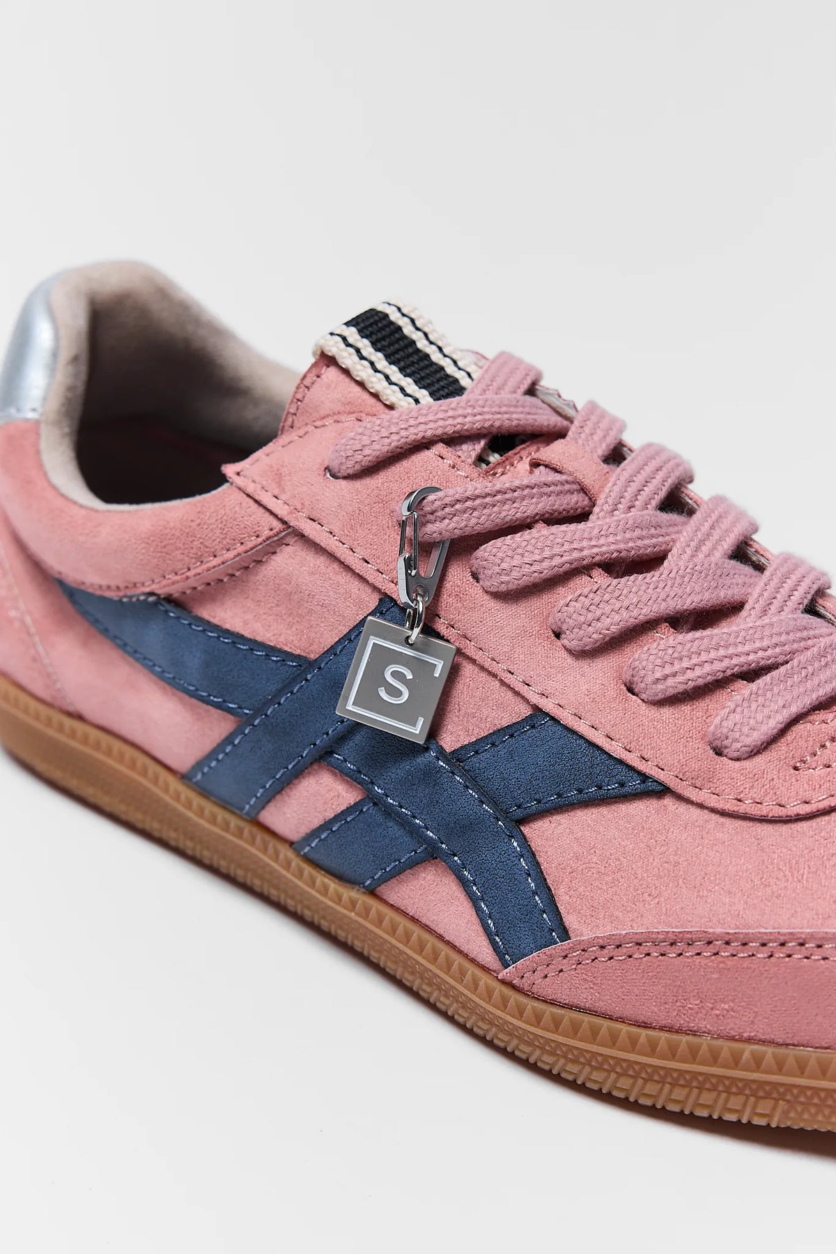 Pink faux suede sneakers with navy stripe and silver charm close-up - Detail View | Avara