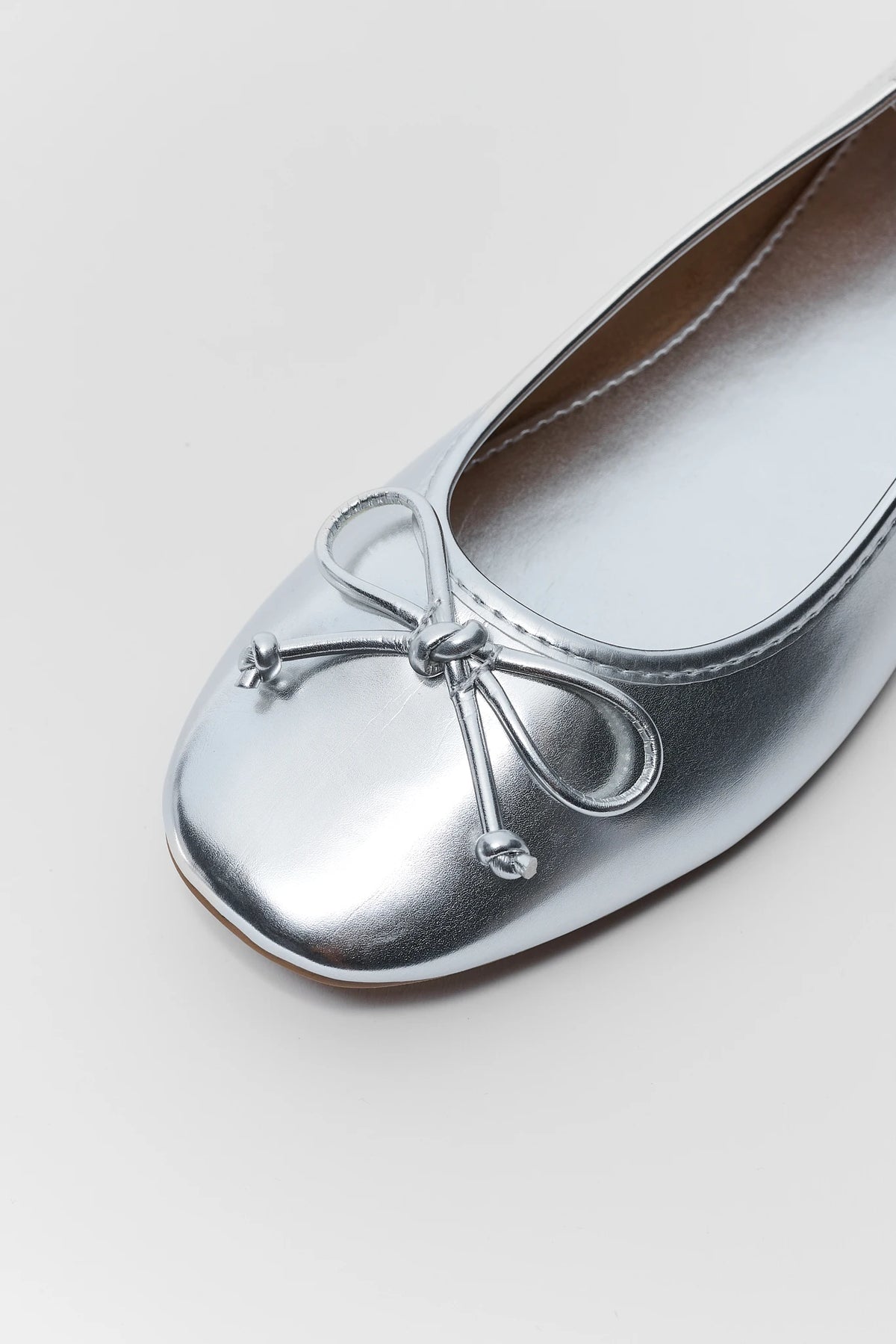 Silver ballet flats with bow - Toe Close-Up, metallic knotted bow detail on round toe | Avara