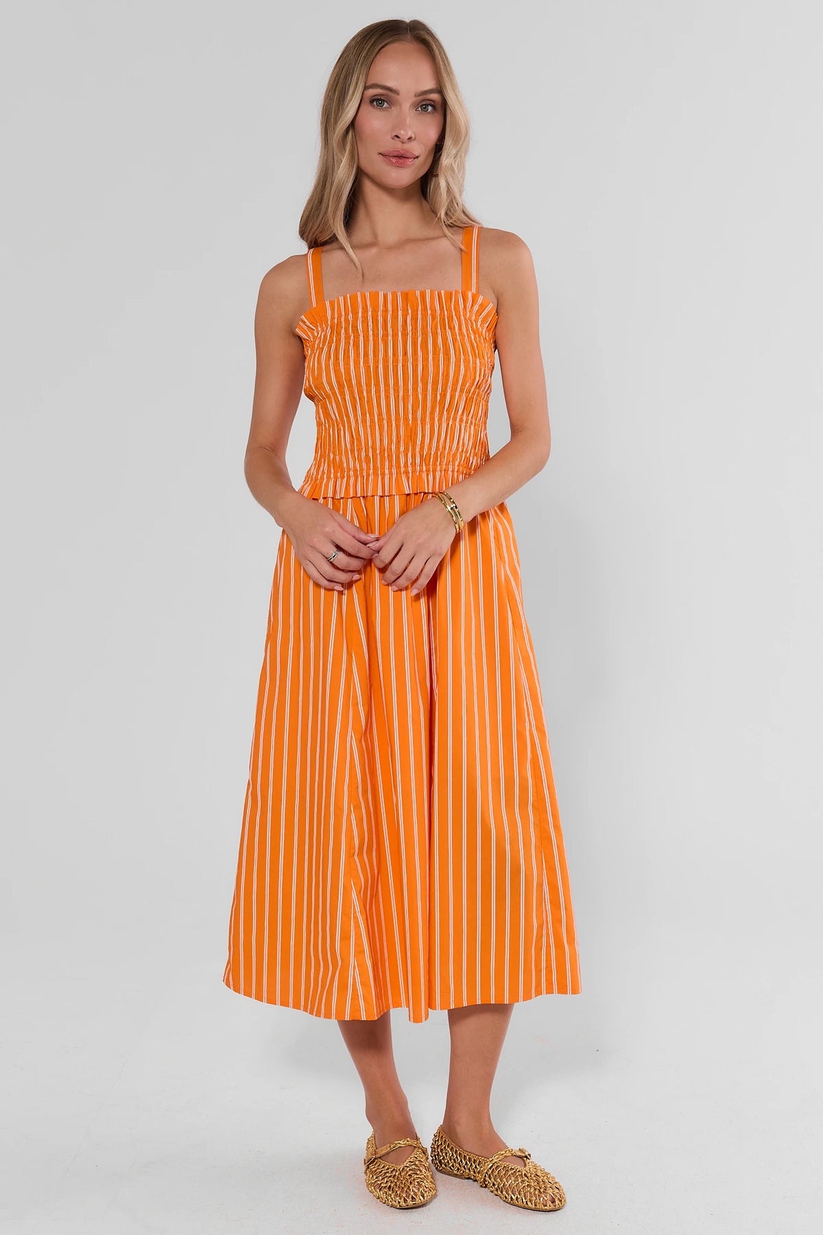 Orange striped smocked midi dress with square neckline and flowy A-line skirt - Full Length On Model | Avara