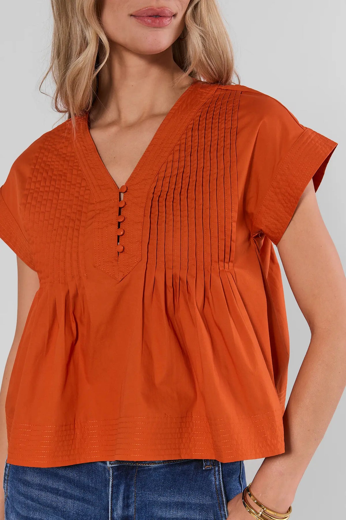 Orange Pleated Button Up Top close-up showing textured pintuck and button placket detail | Avara