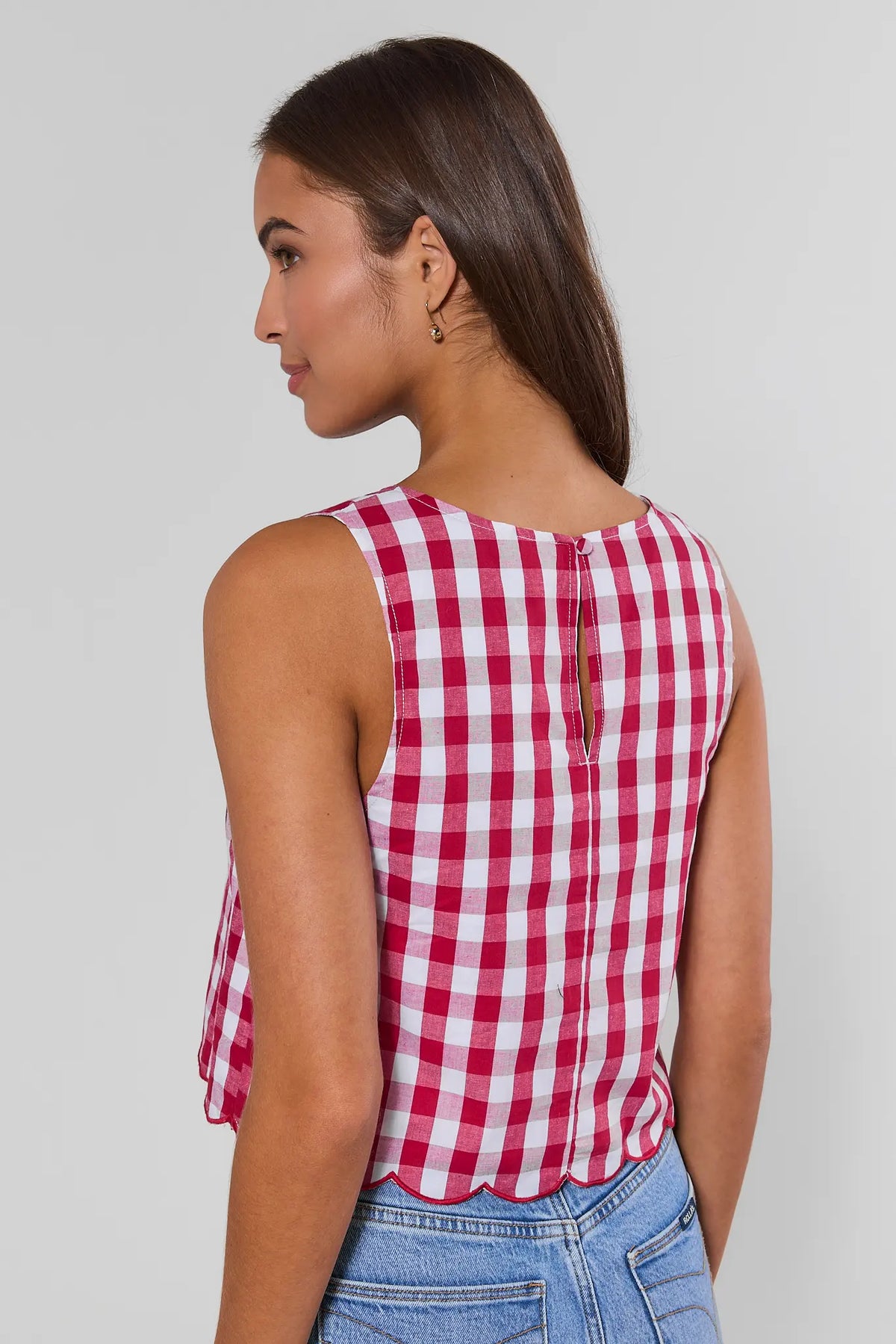 Back view of red gingham tank top showing keyhole closure and scalloped hem, paired with blue jeans | Avara