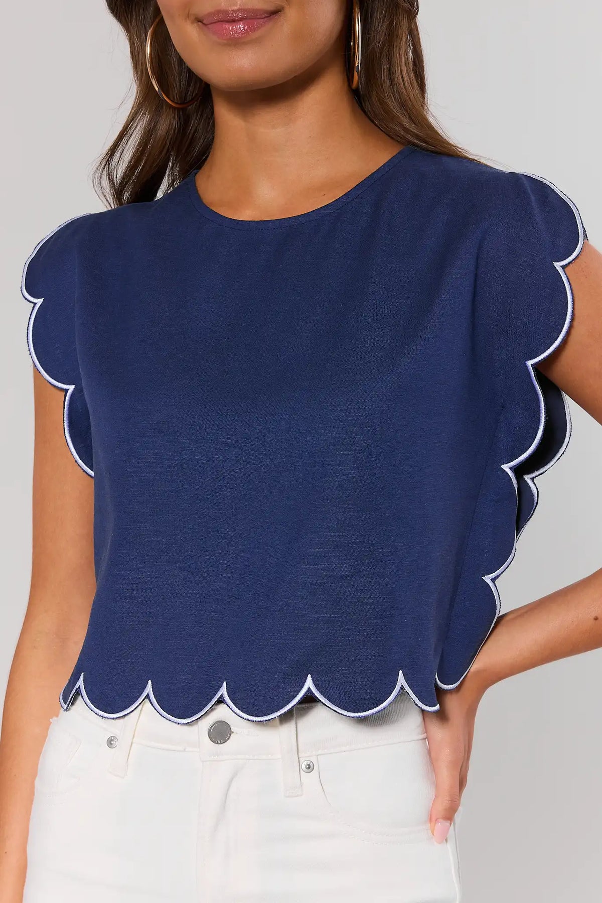 Navy scallop top close-up showing white contrast trim detail on hem and sleeves - Detail View | Avara