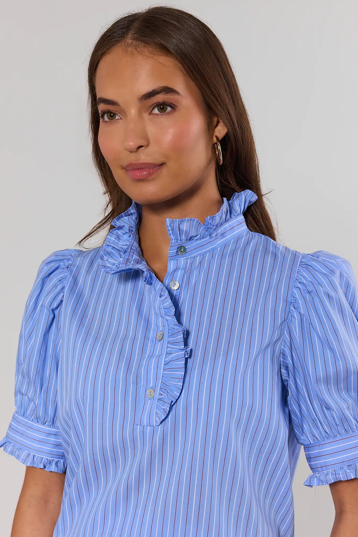 Close-up of blue striped puff sleeve top ruffle collar and button placket detail | Avara