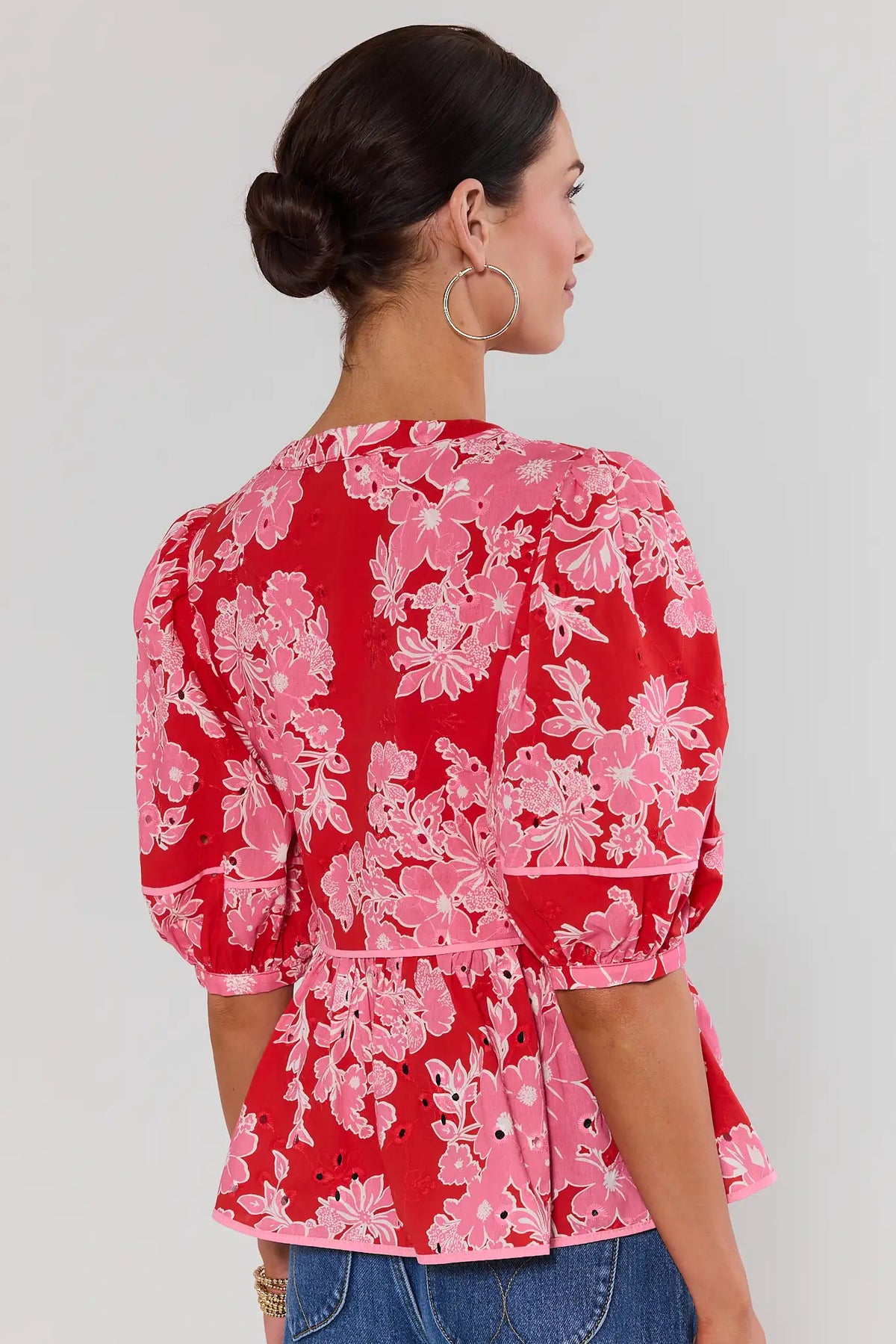 Back view of red floral eyelet peplum top showing pink floral print and peplum hem detail | Avara