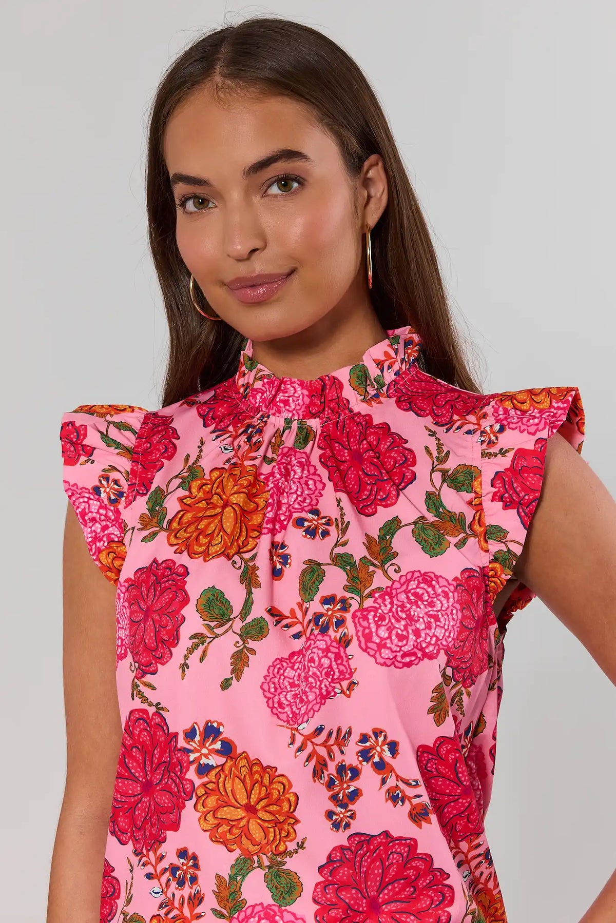 close up Woman wearing a pink floral dress against a plain background