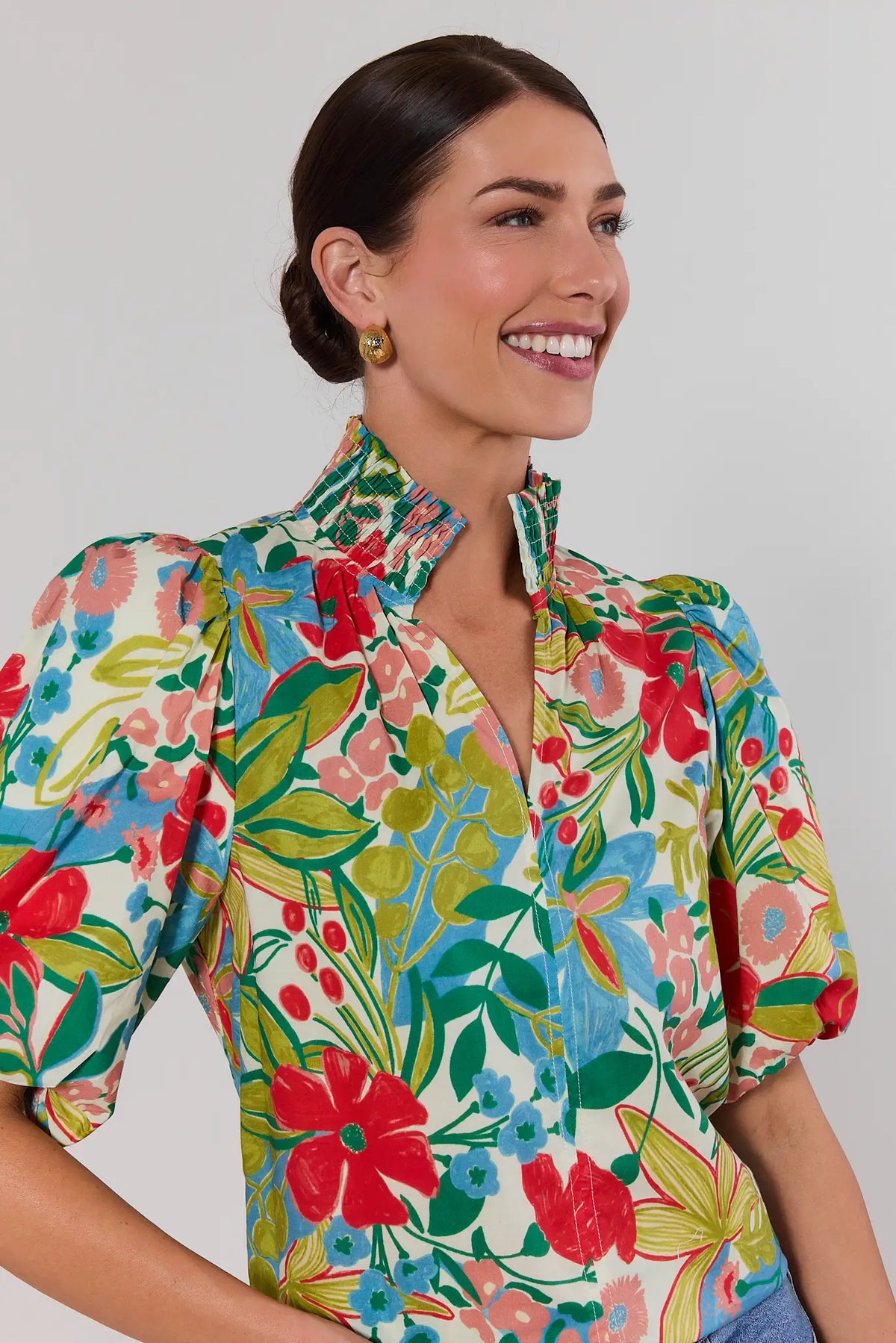 close up Woman wearing a colorful floral blouse against a plain background