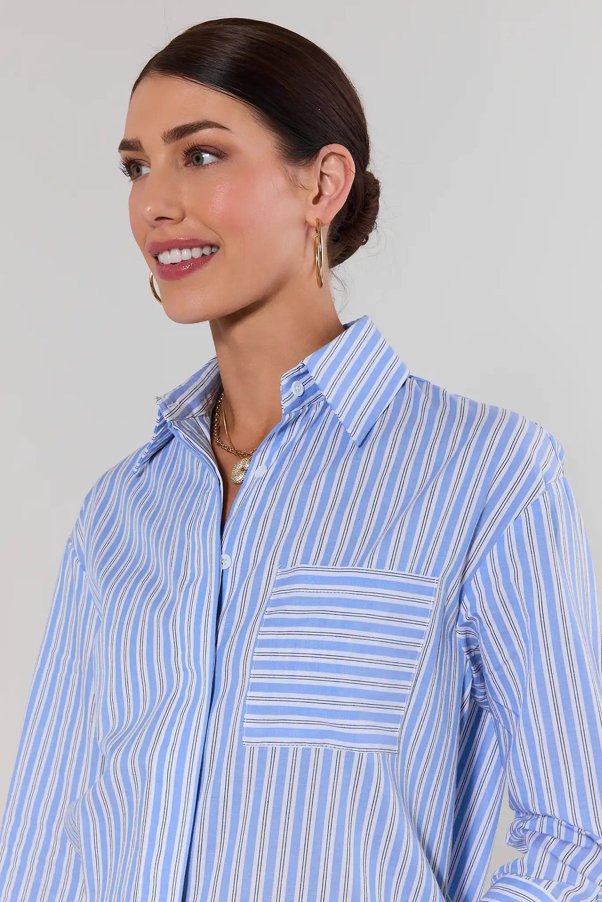Close-up of blue and white striped button up top with chest pocket and spread collar | Avara