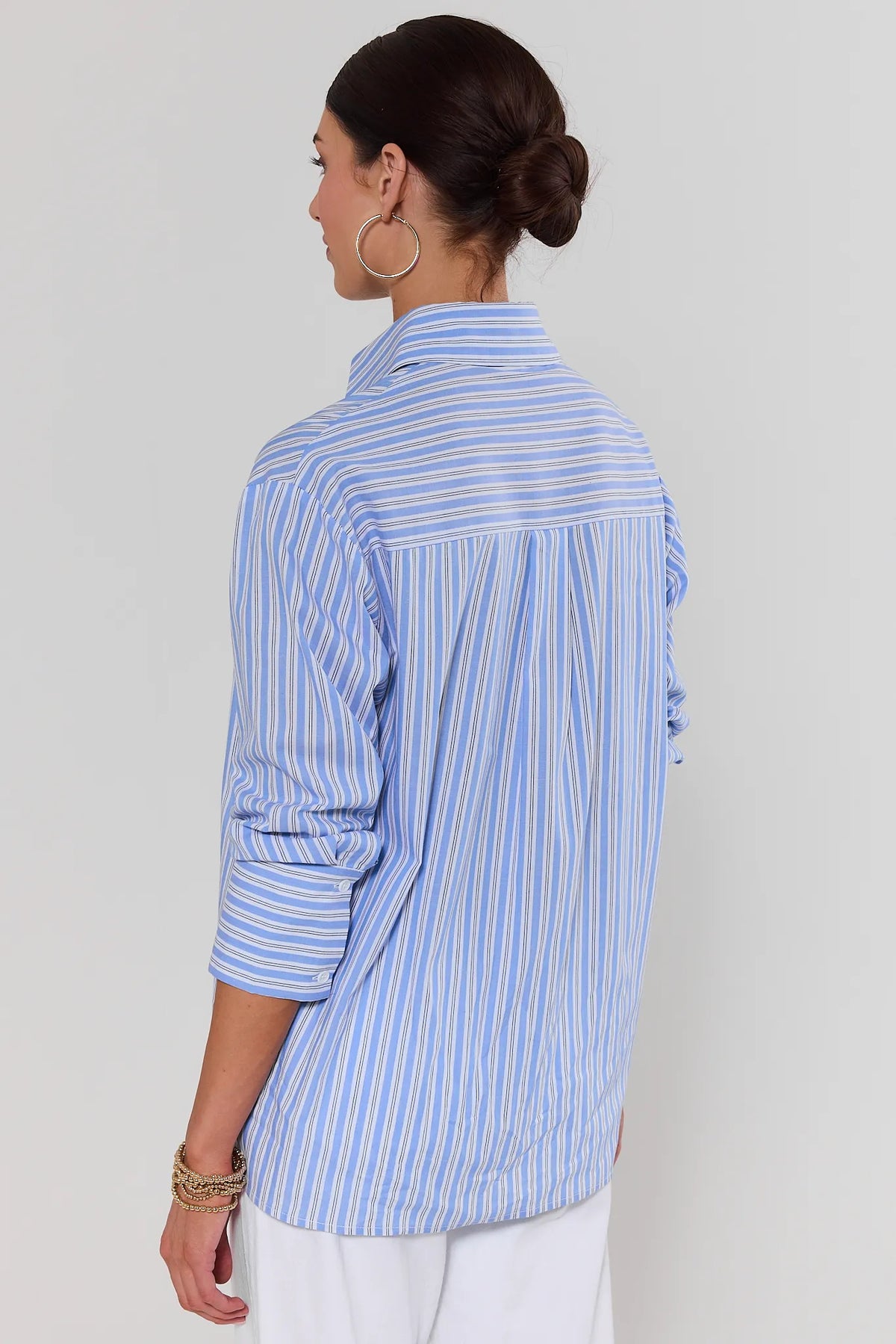 Back view of blue striped button up top showing relaxed oversized silhouette on model | Avara