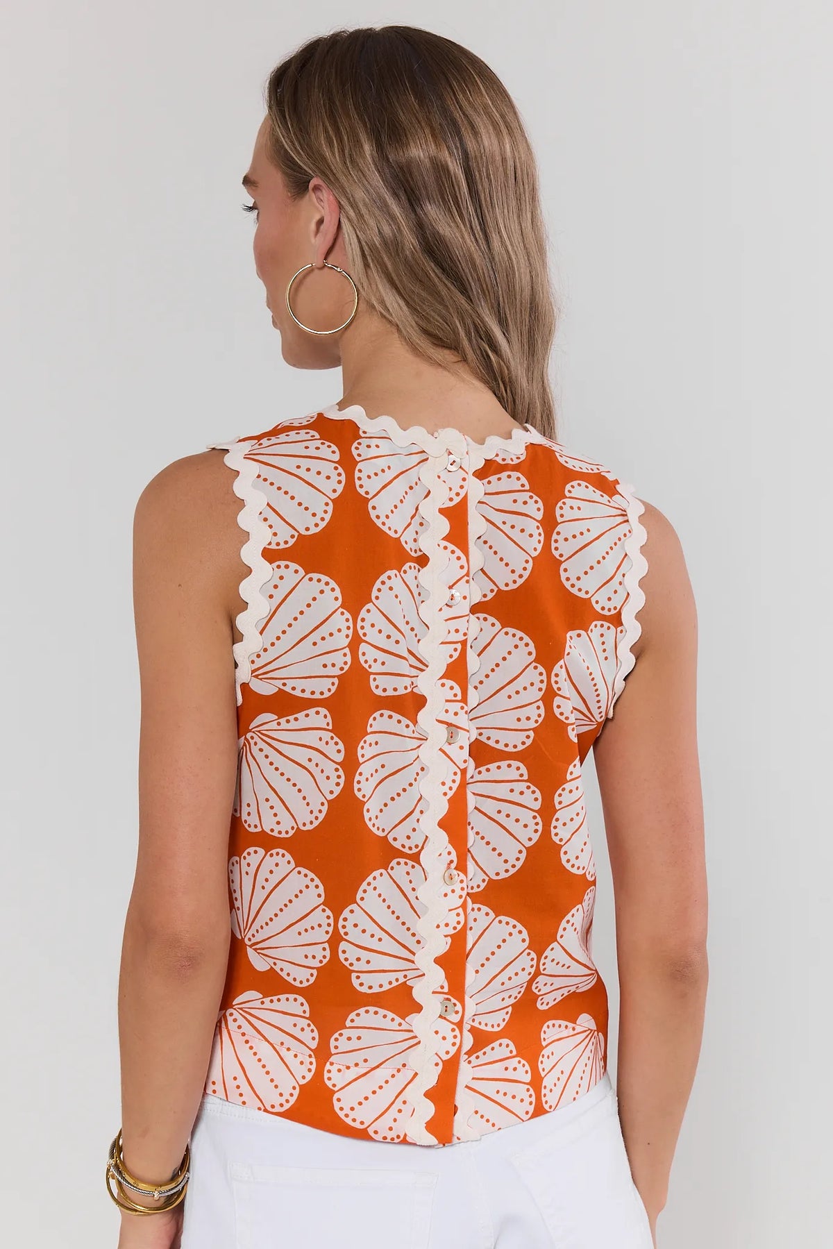 Orange shell print women's tank top back view with ric-rac trim, styled with white pants | Avara