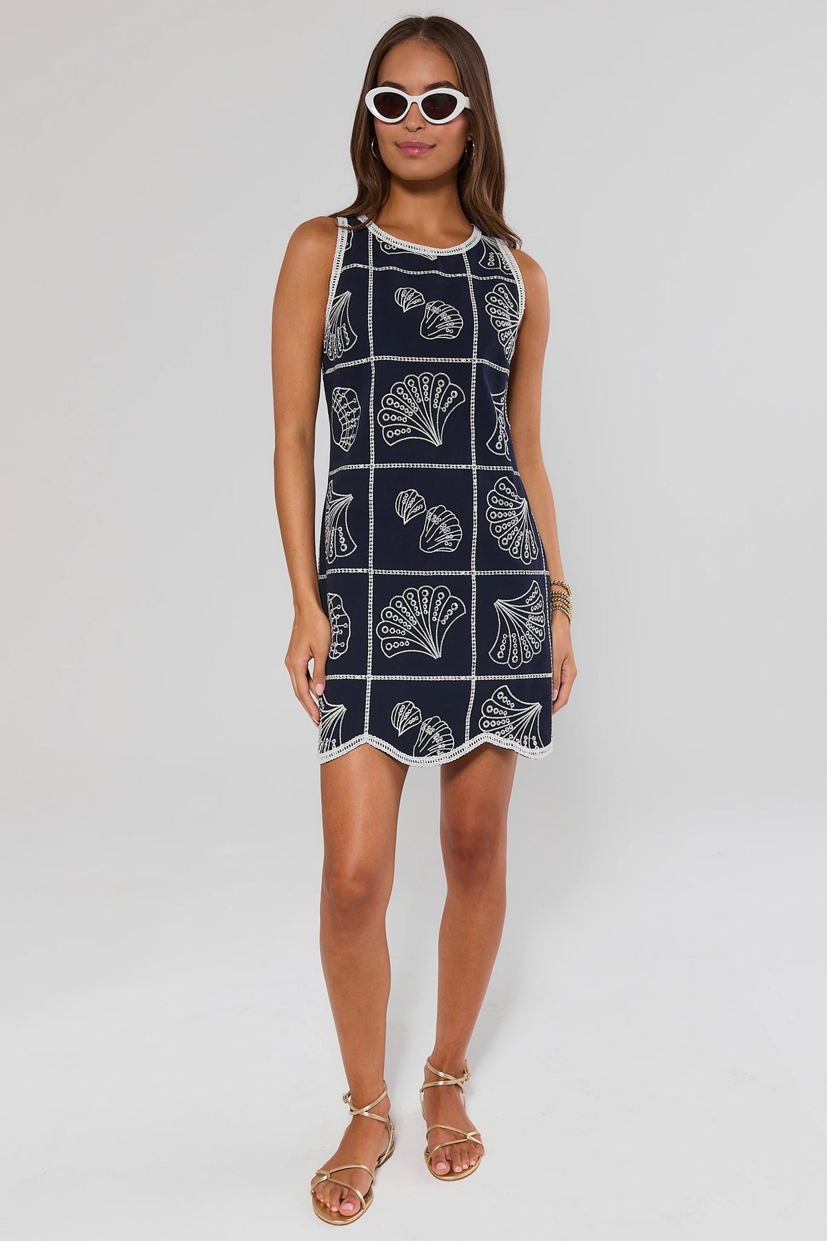 Woman wearing a navy shell dress with white patterns on a background