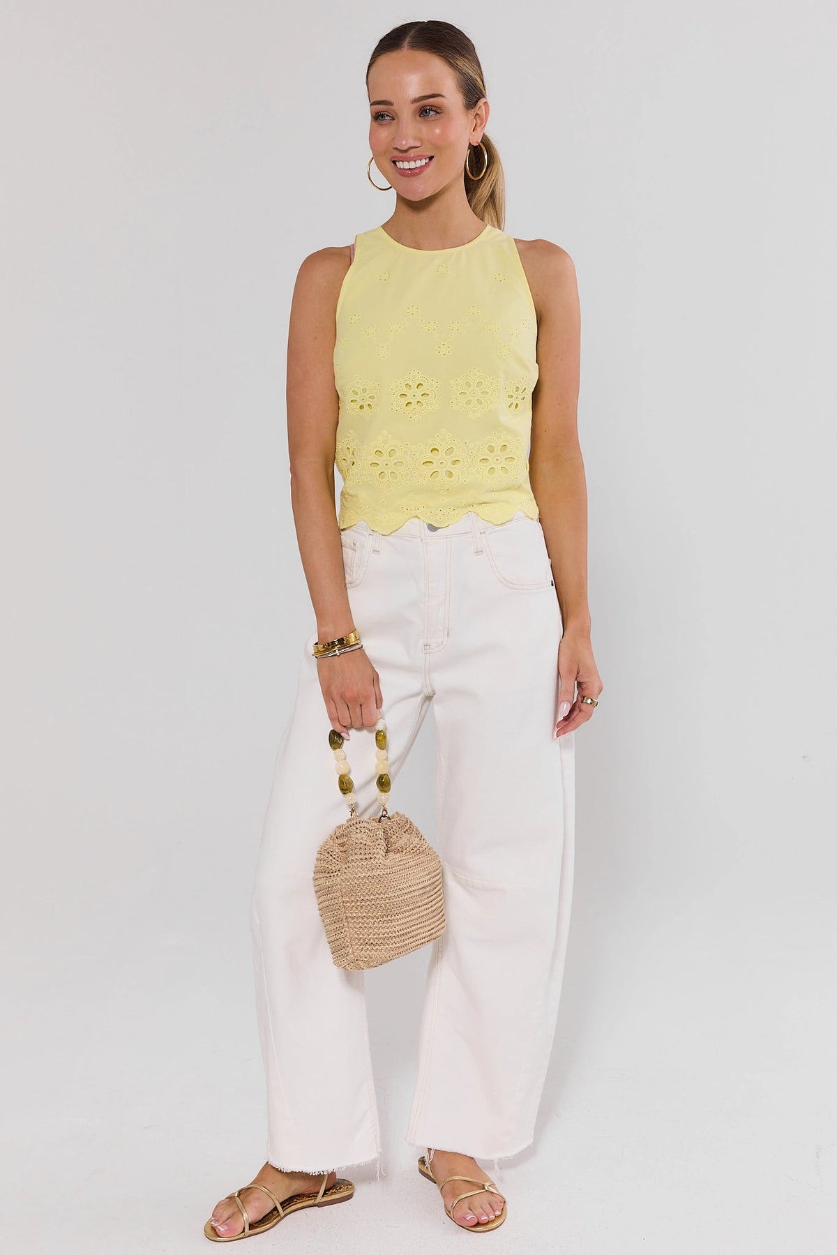 Yellow Eyelet Tank Top styled with white wide-leg pants and woven bag, full-length on model | Avara