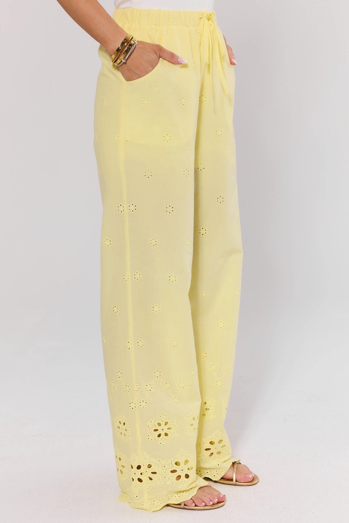 Yellow Eyelet Wide Leg Pants showing side pocket and scalloped eyelet hem - Side View On-Model | Avara