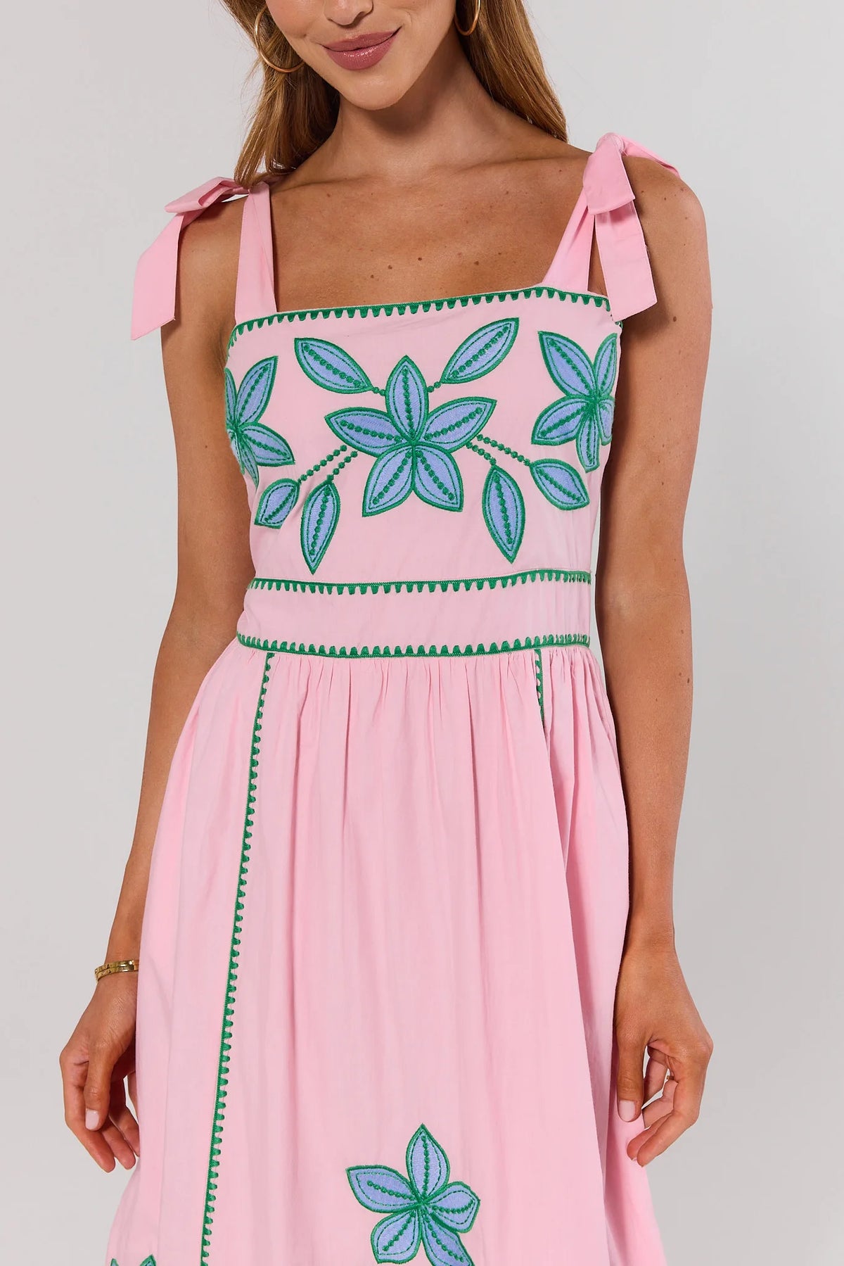 close up Pink dress with floral patterns on a plain background