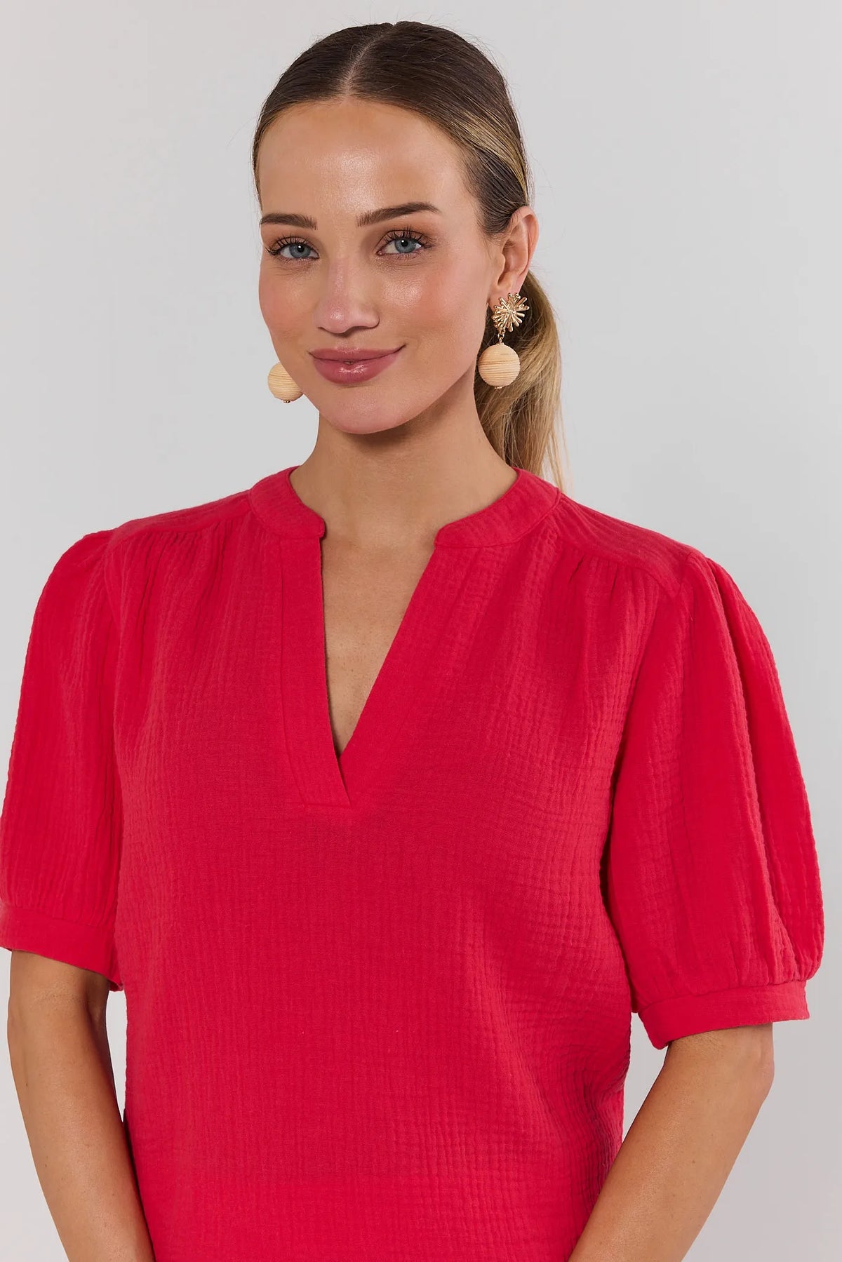 Close-up of red gauze top split neckline and puff sleeve detail - Neckline Detail | Avara