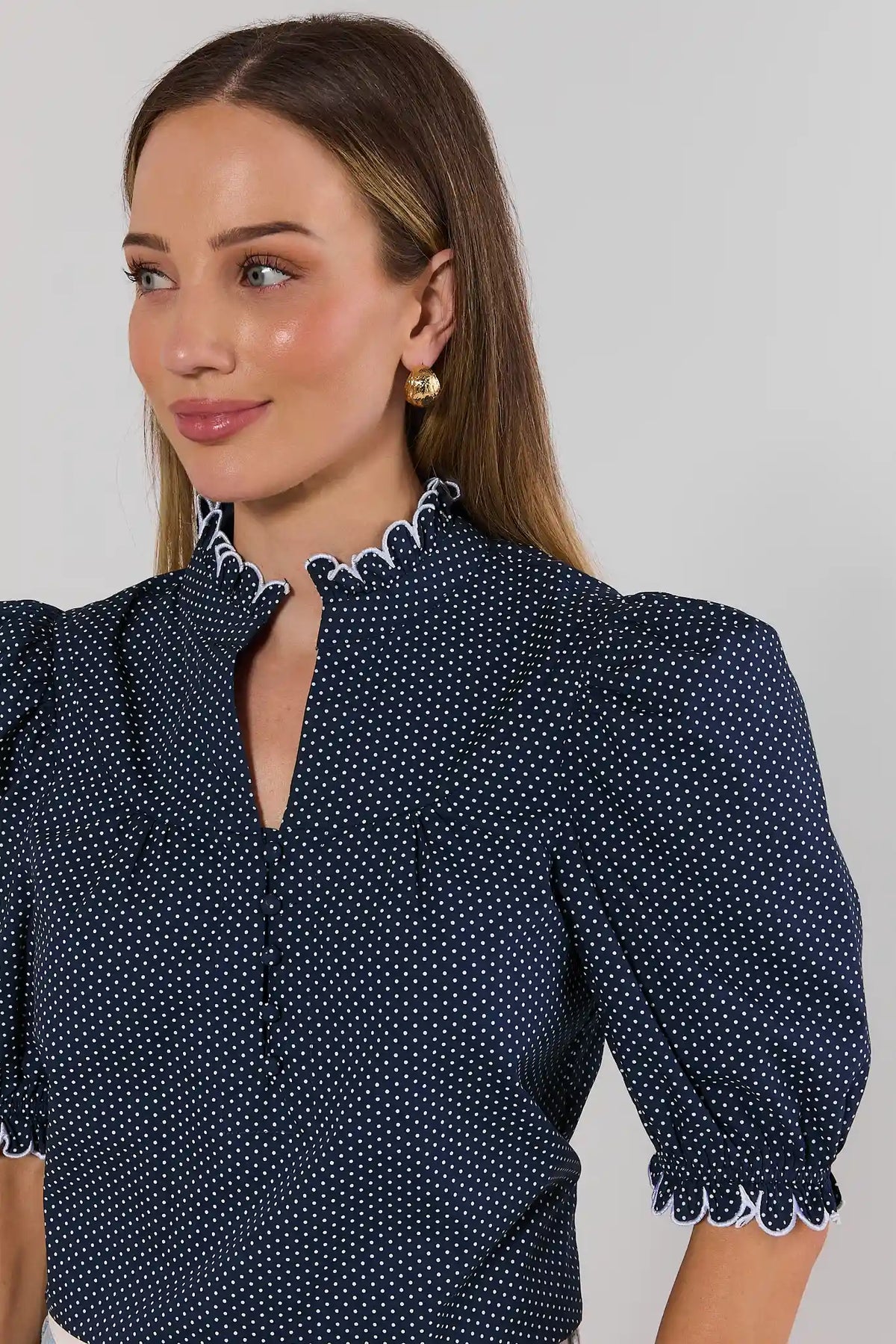 Close-up of navy polka dot top with white scallop ruffle neckline and smocked puff sleeves - Detail View | Avara