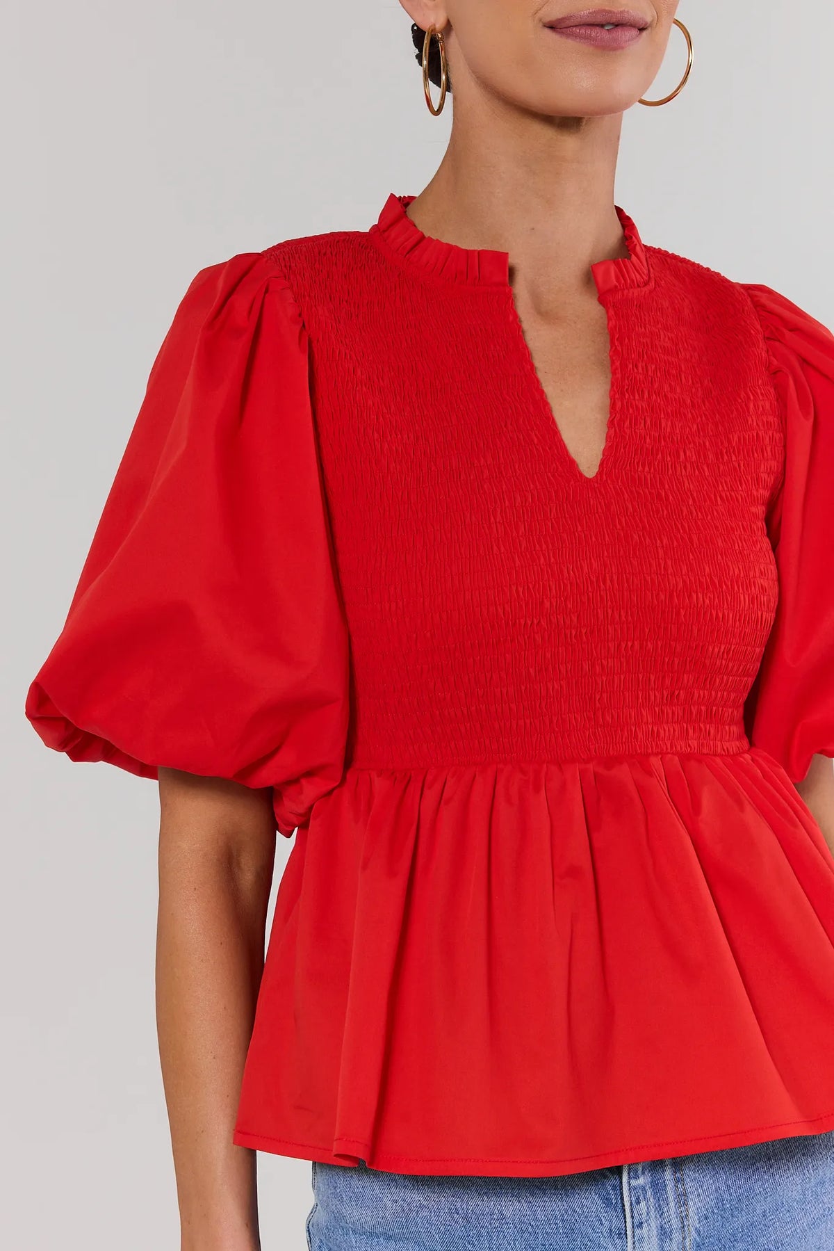 Red peplum top smocked bodice and v-neckline close-up detail - Close-Up View | Avara